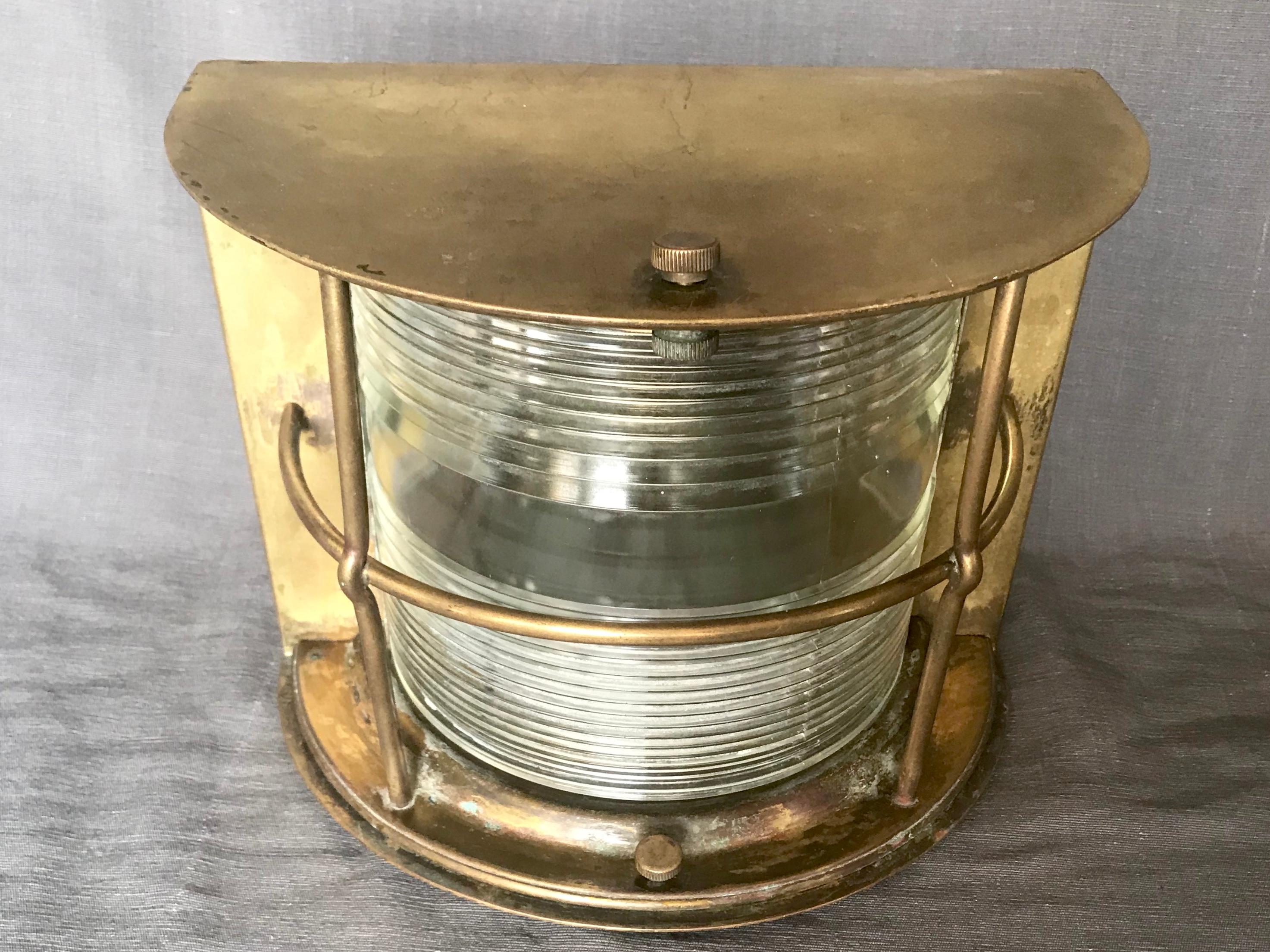 Italian brass ship lamp. Vintage nautical brass convex ship lamp / sconce with convex ribbed Holophane glass shade; with original patina and newly rewired.
Italy, 1940s
Dimensions: 9.25