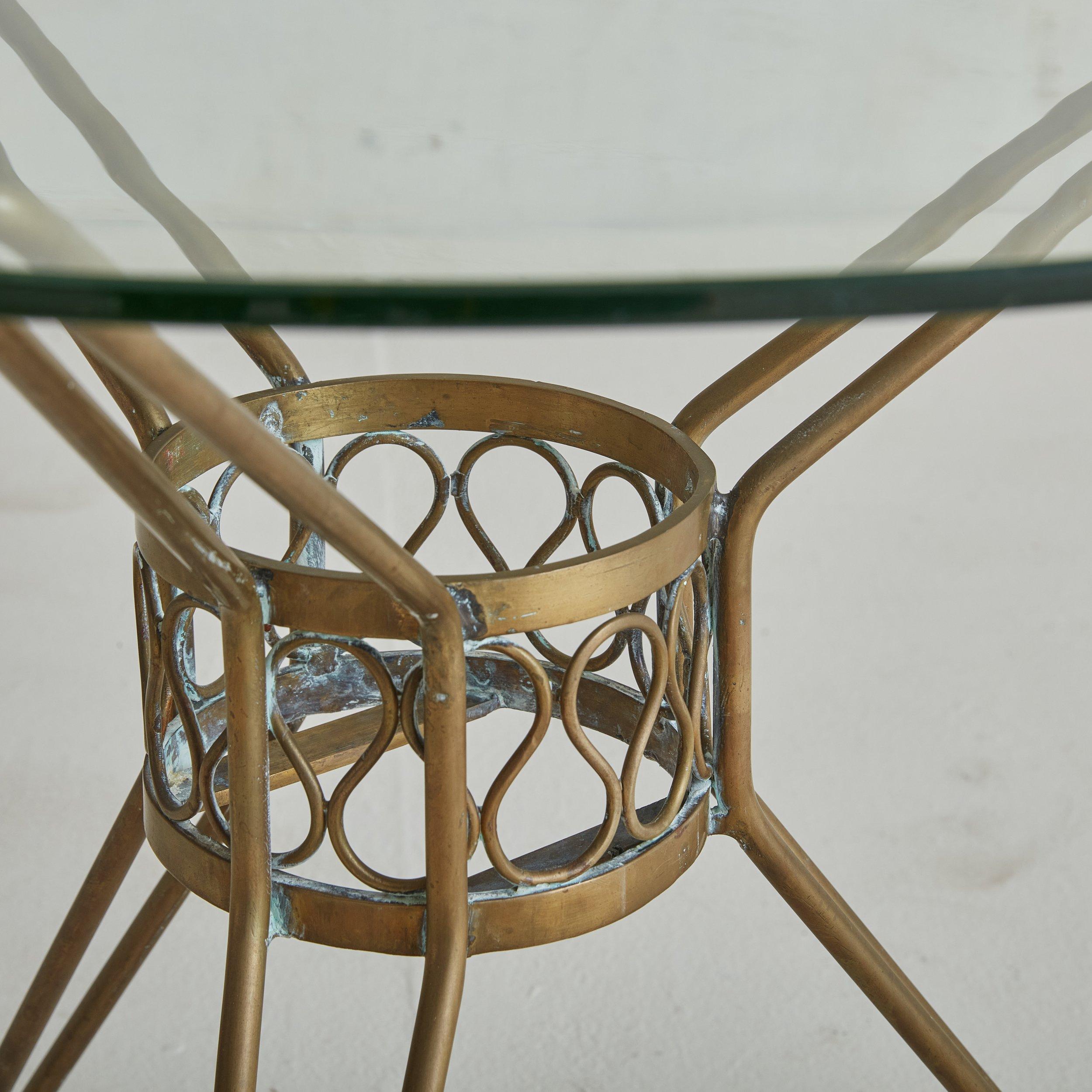 A 1960s Italian accent table featuring a beautifully patinated brass and a charming squiggle motif along the frame. Completed with a new round glass top. 
 

DIMENSIONS: 26.25
