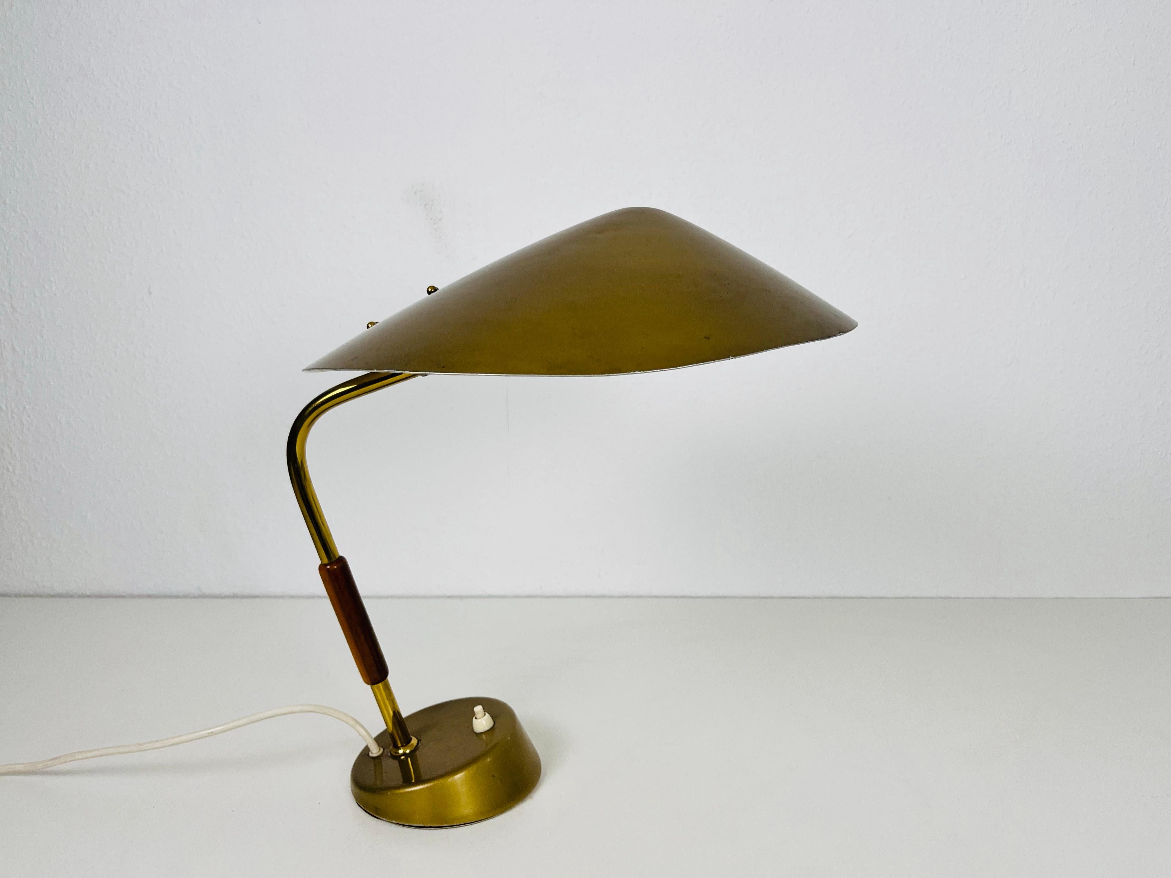 Eine italienische Tischlampe aus den 1960er Jahren. Die Leuchte hat ein außergewöhnliches Design, das an die Tischleuchten von Stilnovo erinnert. Er ist aus Messing mit einem schönen Holzelement.

Die Leuchte benötigt eine E27 (US E26) Glühbirne.