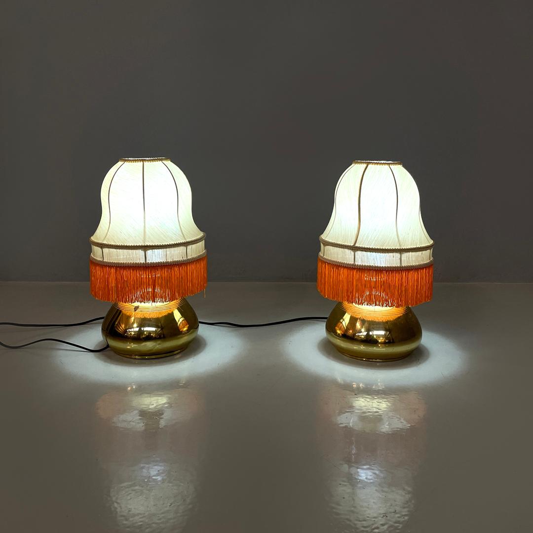 Italienische Messing-Tischlampen mit beigem Lampenschirm und orangen Fransen, 1980er Jahre
Ein Paar Tischlampen mit rundem Sockel. Der runde Lampenschirm aus beigefarbenem Stoff folgt geschwungenen Formen, die von oben beginnen und sich in der Mitte
