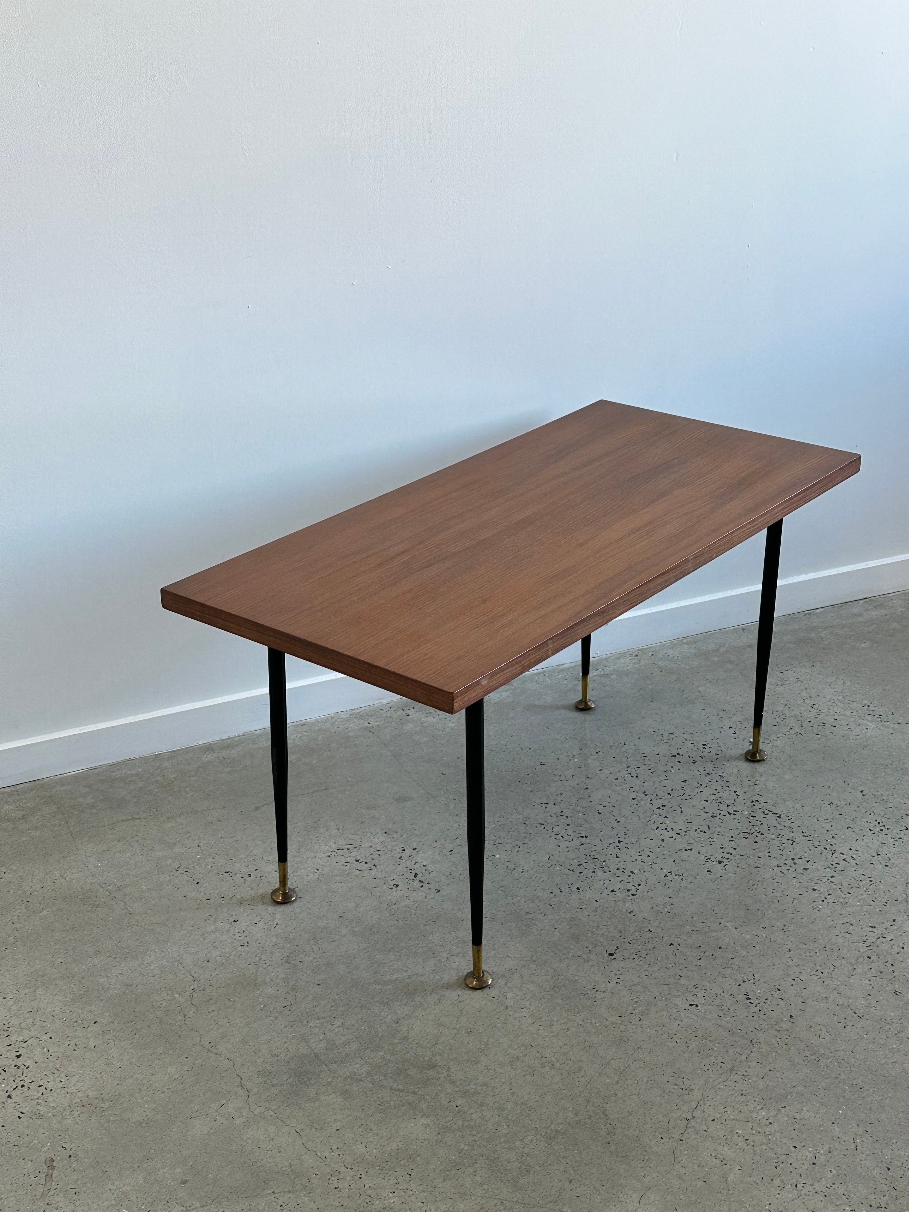 made in Italy during the 1950s. It features a combination of brass and teak timber materials, which were popular choices for furniture design during that era.

Brass was often used for the legs or structural elements of furniture due to its