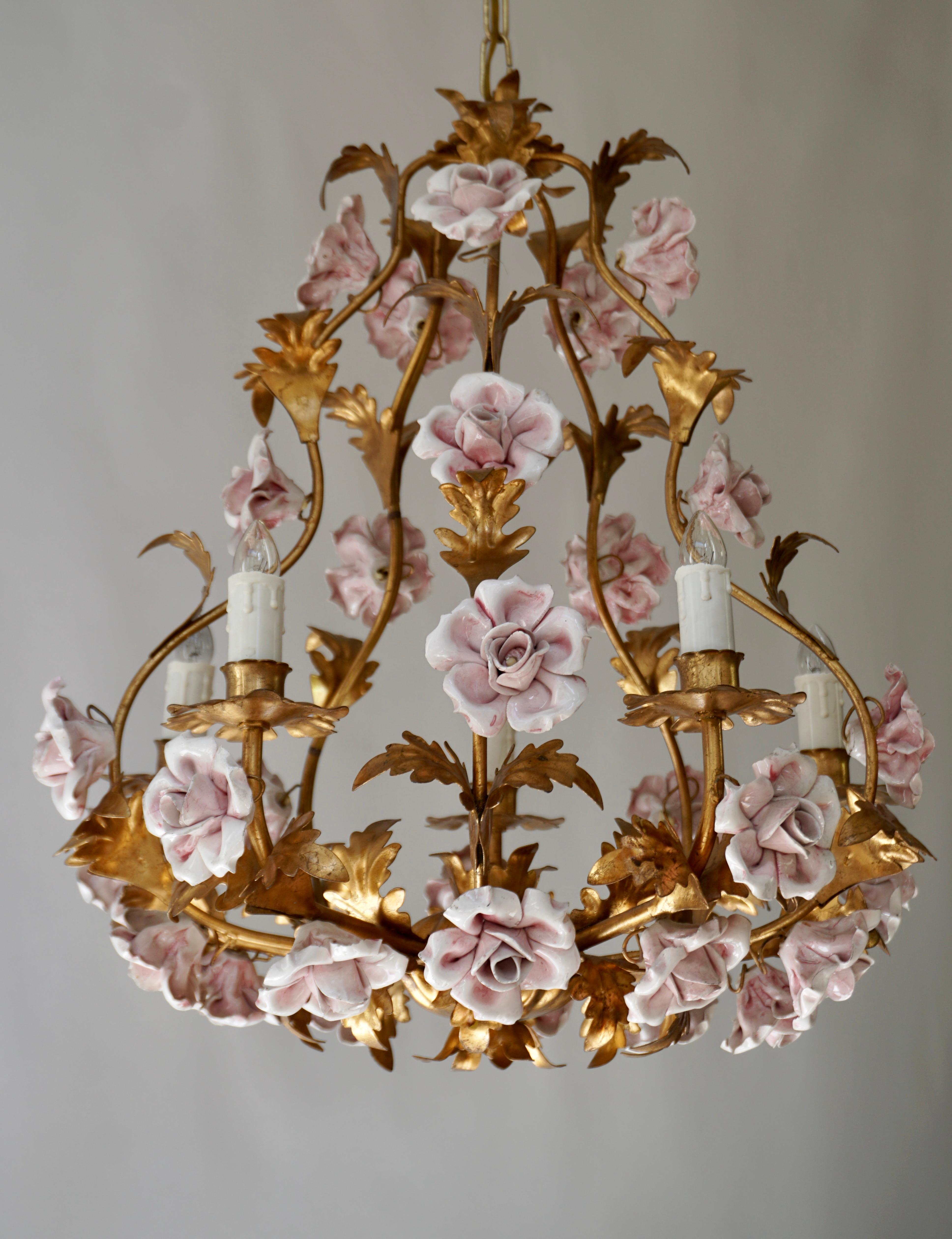 Italian Hollywood Regency six light chandelier in brass with pink porcelain flowers. 

Diameter 50 cm - 19.7 inch.
Height fixture 55 cm - 21.6 inch.
Total height including the chain 70 cm - 27.5 inch.

We have the same chandelier but with pink
