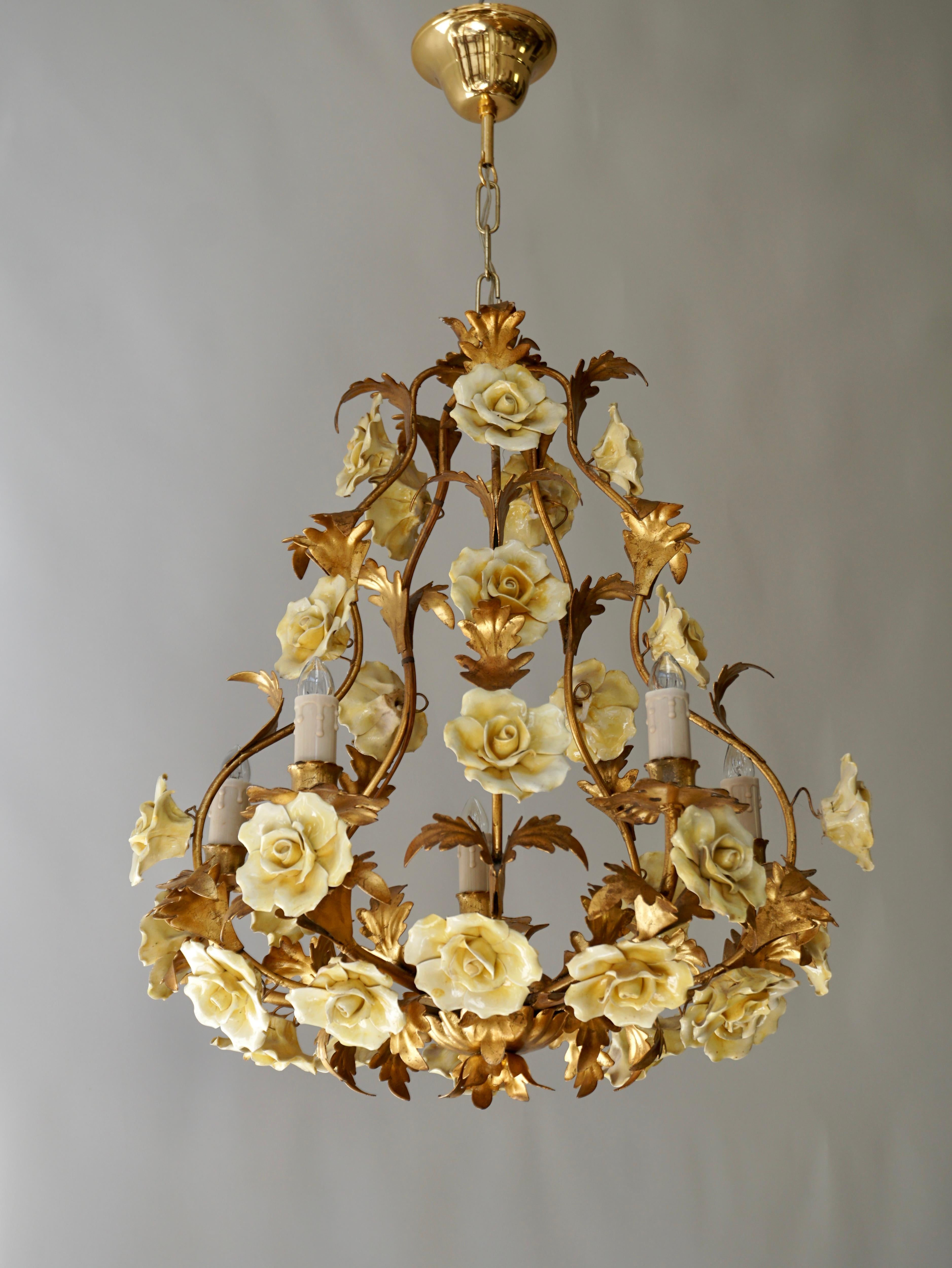Italian Hollywood Regency six light chandelier in brass with yellow porcelain flowers. 

Diameter 50 cm - 19.7 inch.
Height fixture 55 cm - 21.6 inch.
Total height including the chain 70 cm - 27.5 inch.

We have the same chandelier but with pink