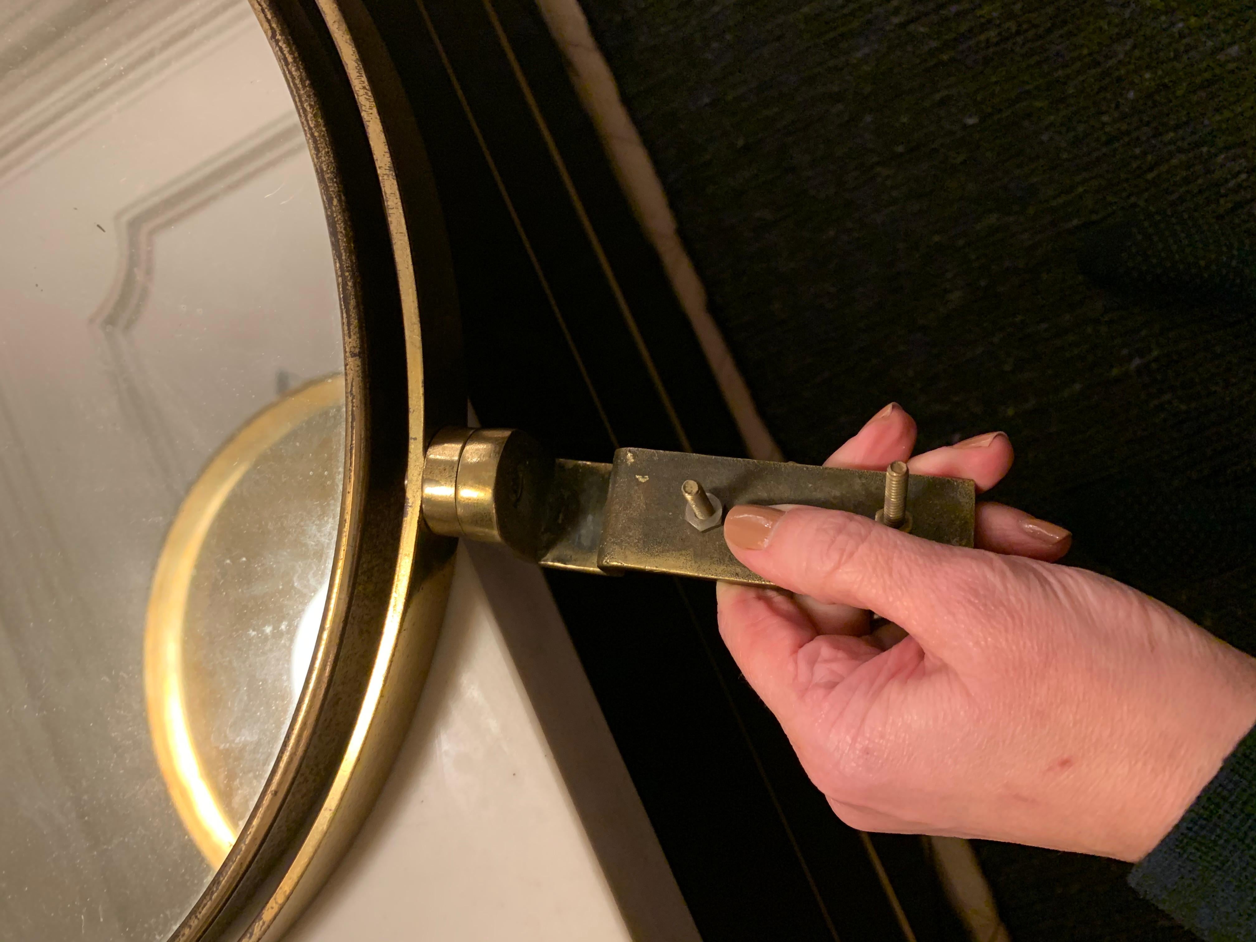 Tilting and swiveling vanity mirror, brass profile and mirrored glass. 1950s. Comes with hardware to attach to the vanity or desk. See pictures.