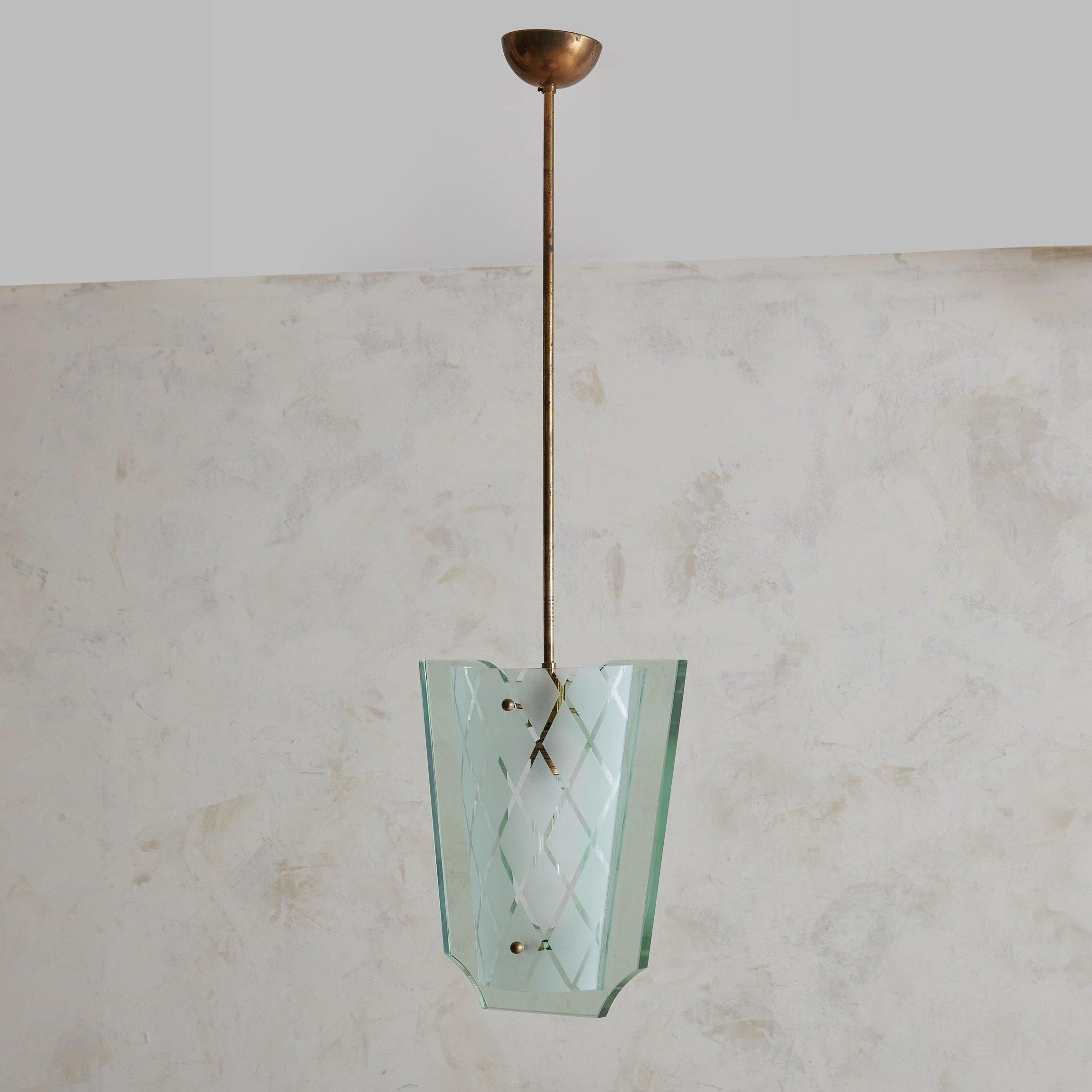 A rare pendant light by Pietro Chiesa for Fontana Arte featuring stunning green hued cut glass, a patinaed brass frame, and original canopy. The brass frame supports a single sheet of glass enclosed by two curved glass panels with etched diamond