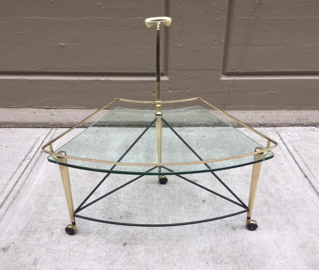 Unique, 1950s Italian bronze bar cart. It has a bronze, black lacquered stretcher and a curved glass top. It also has a long handle. The cart rolls smoothly. It can also be used as a coffee table.
 