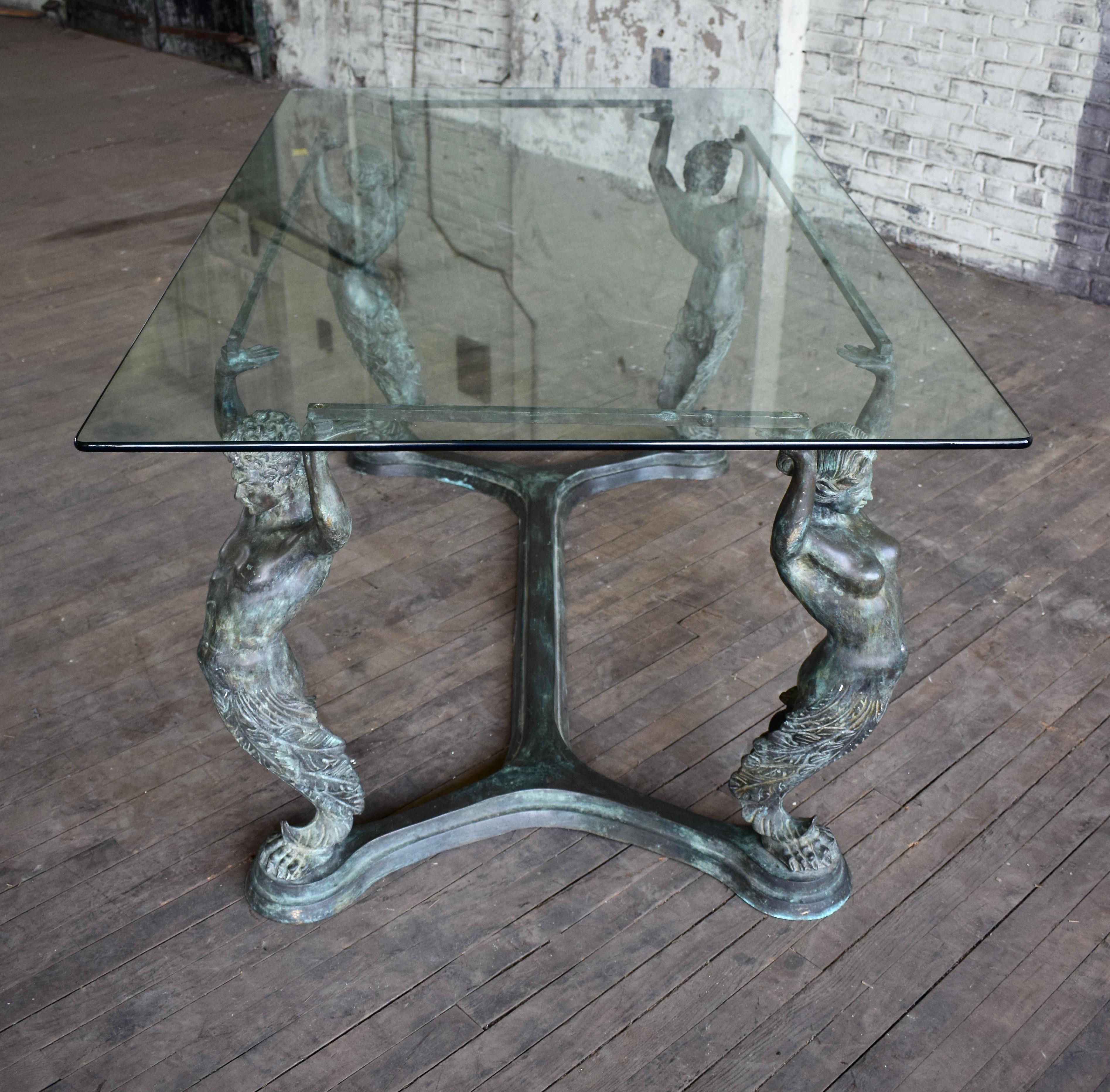 An unusual Italian bronze dining table depicting four supporting Caryatid & Atlas figures with outstretched arms suspending a floating glass top. Base measurements 60