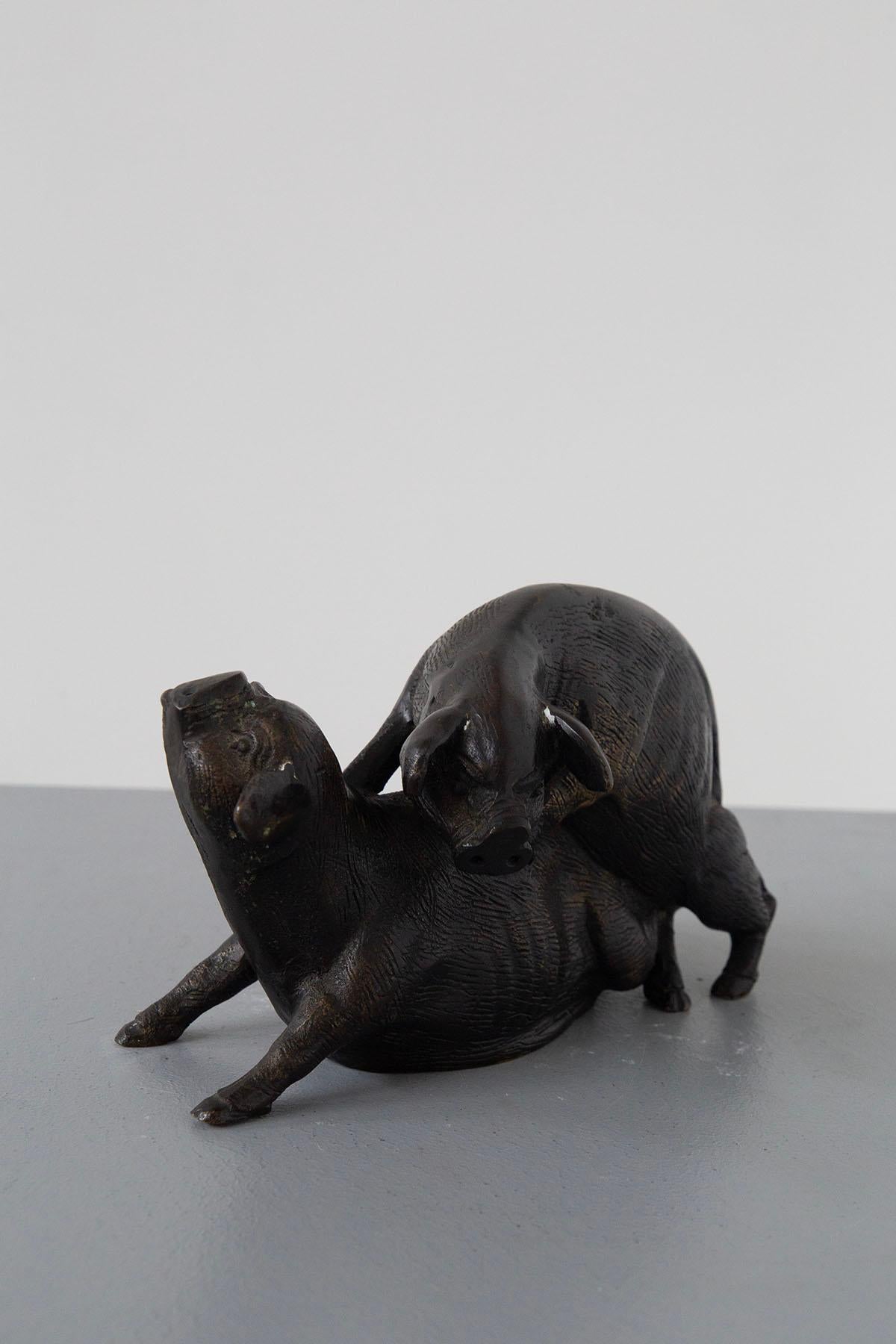 Imagine a small but enchanting Italian bronze sculpture that captures an unexpected moment of nature's beauty. It's a delicate portrayal of Two Mating Pigs, created by a skilled 20th-century bronzist, a testament to the artistry and craftsmanship of