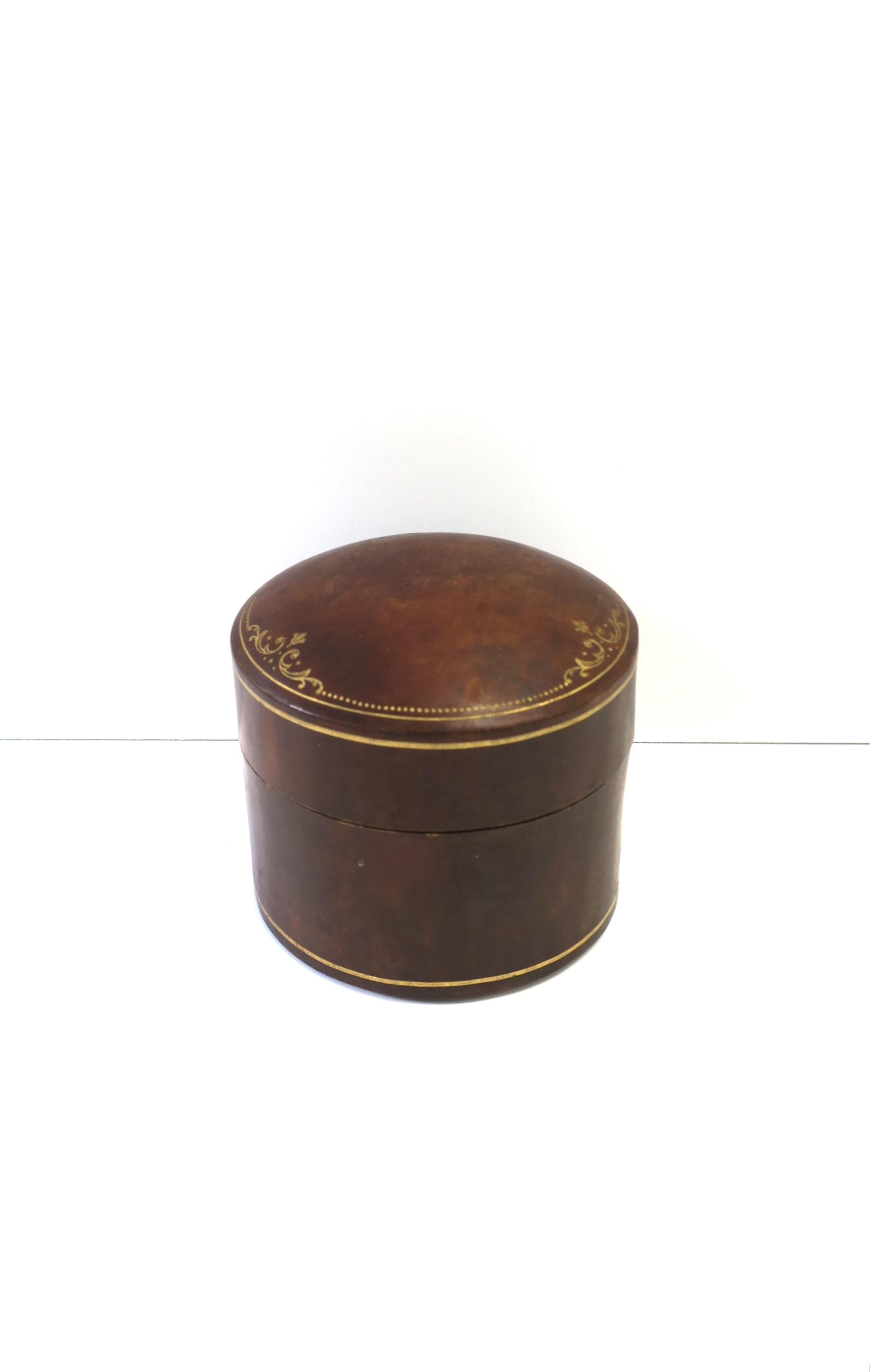 An Italian brown leather cylindrical jewelry box with gold embossing, circa mid-20th century, Italy. Box can hold jewelry or other items on a desk, vanity, walk-in-closet, etc. Dimensions: 4