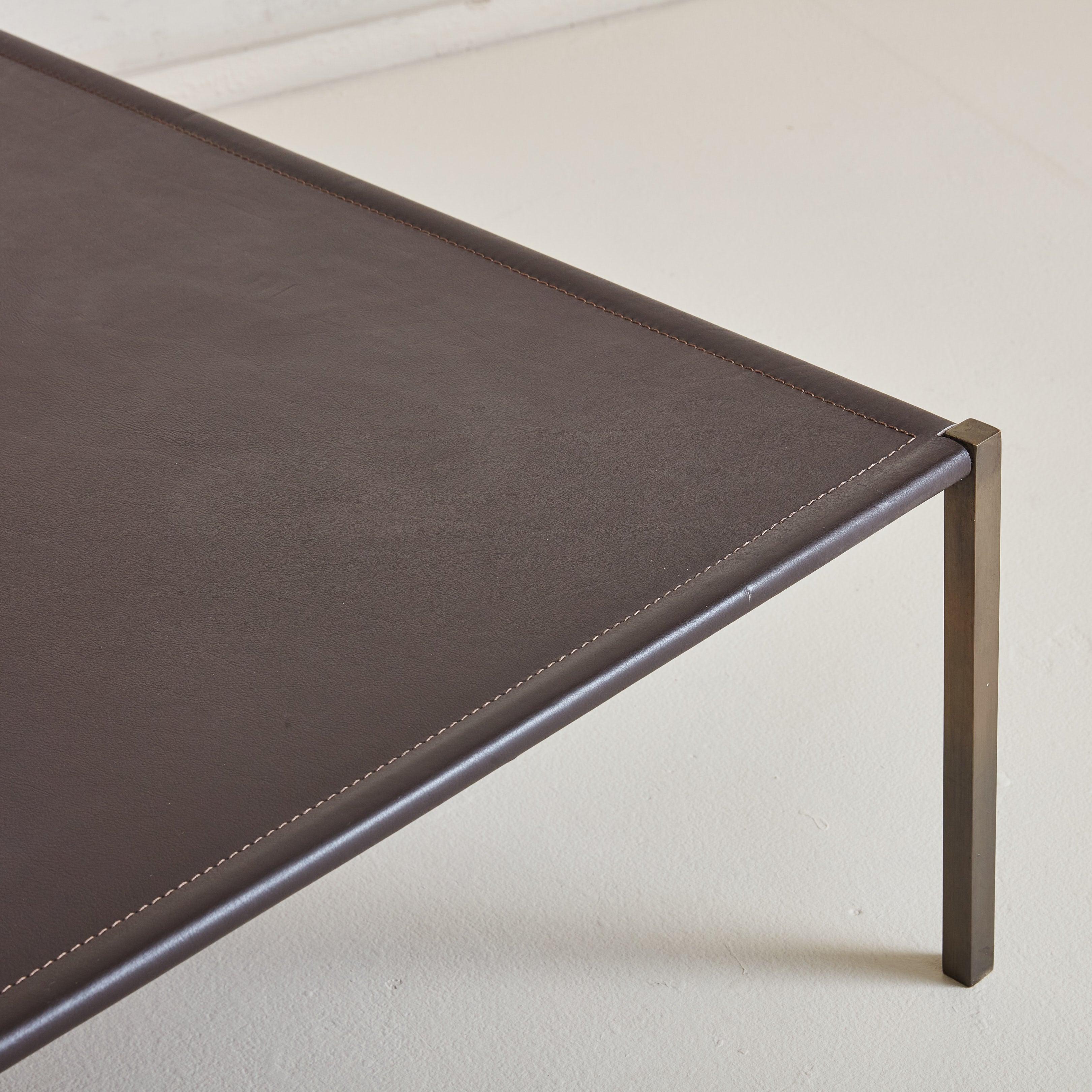 Ein zeitgenössischer Couchtisch aus einer Hermes-Boutique in Italien. Die minimalistische, quadratische Silhouette besteht aus vier rechteckigen, patinierten Bronzebeinen und einer Lederplatte in einem satten, tiefbraunen Farbton mit
