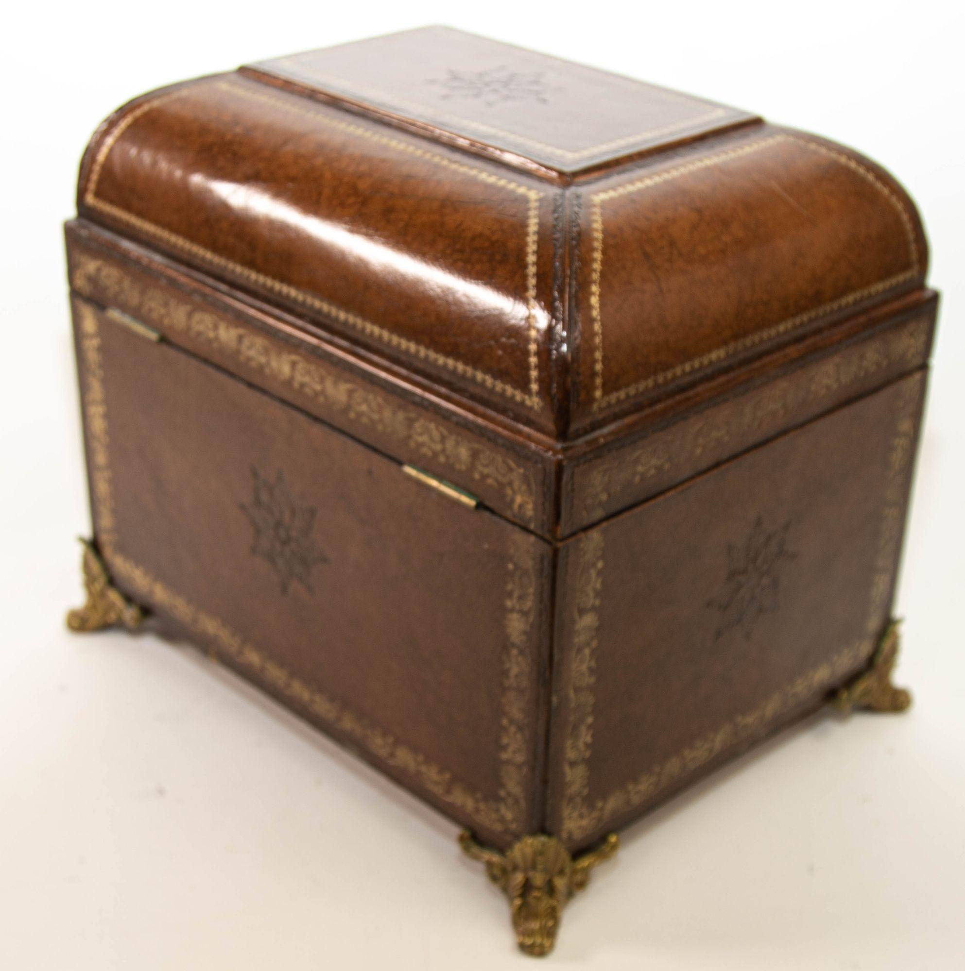 Italian Brown Leather Jewelry Box with Gold Tooling.
Large Italian gilt tooled leather wrapped table box, with domed top gilt decoration, raised on four bronze paw feet.
Vintage leather wrapped trunk with solid brass ornate feet, the top opens to