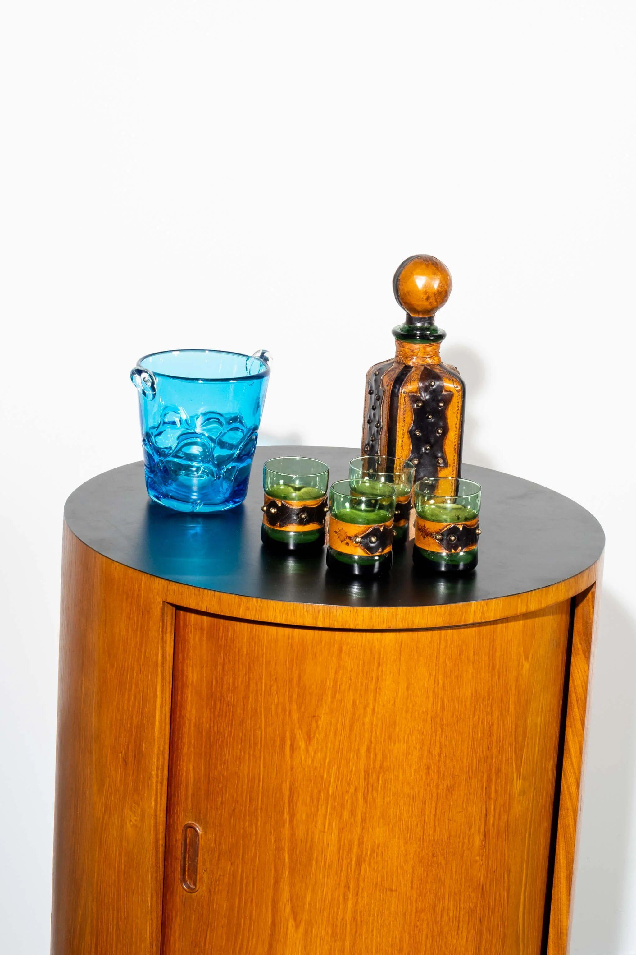 Un set sorprendente di 4 bicchieri e un decanter. Una base di vetro verde vanta un dettagliato rivestimento in pelle, bello e decorativo. Timbro 