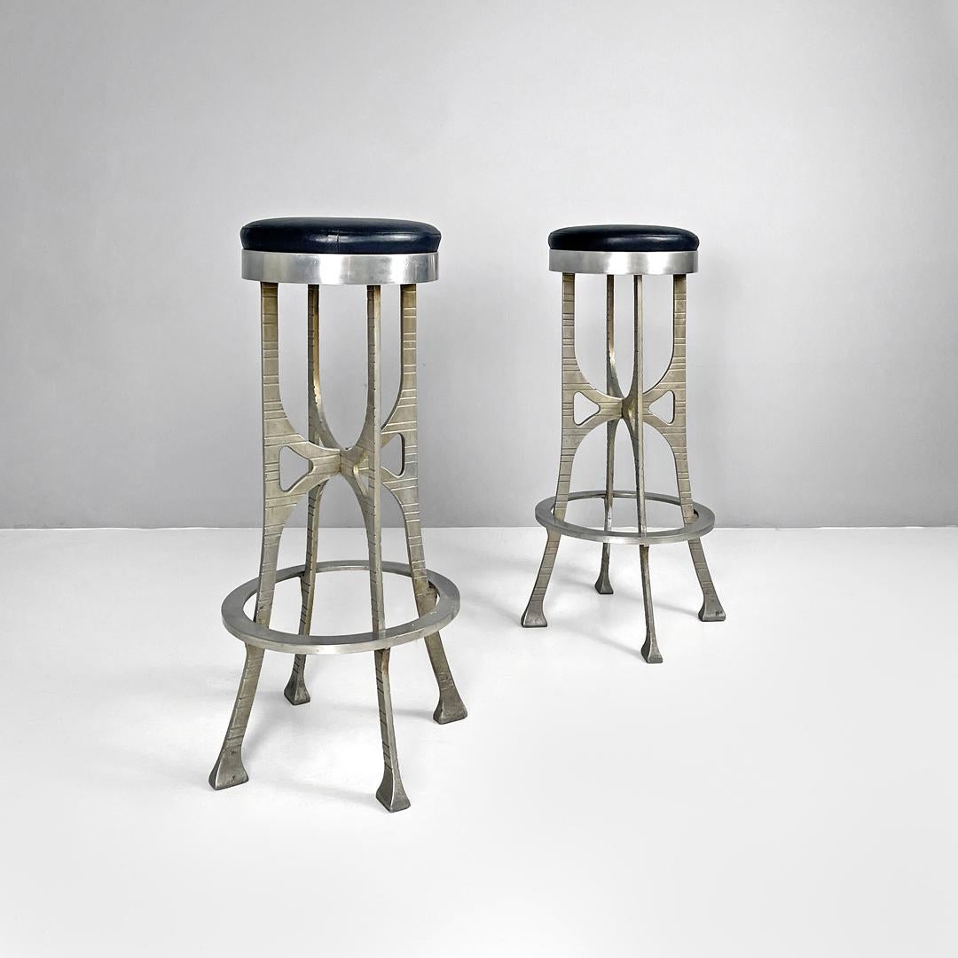 Italian brutalist style high stools in aluminum and black leather, 1940s
Pair of brutalist style high stools with round padded seat covered in black leather. The structure is in cast aluminium. The legs are decorated with horizontal lines and cross