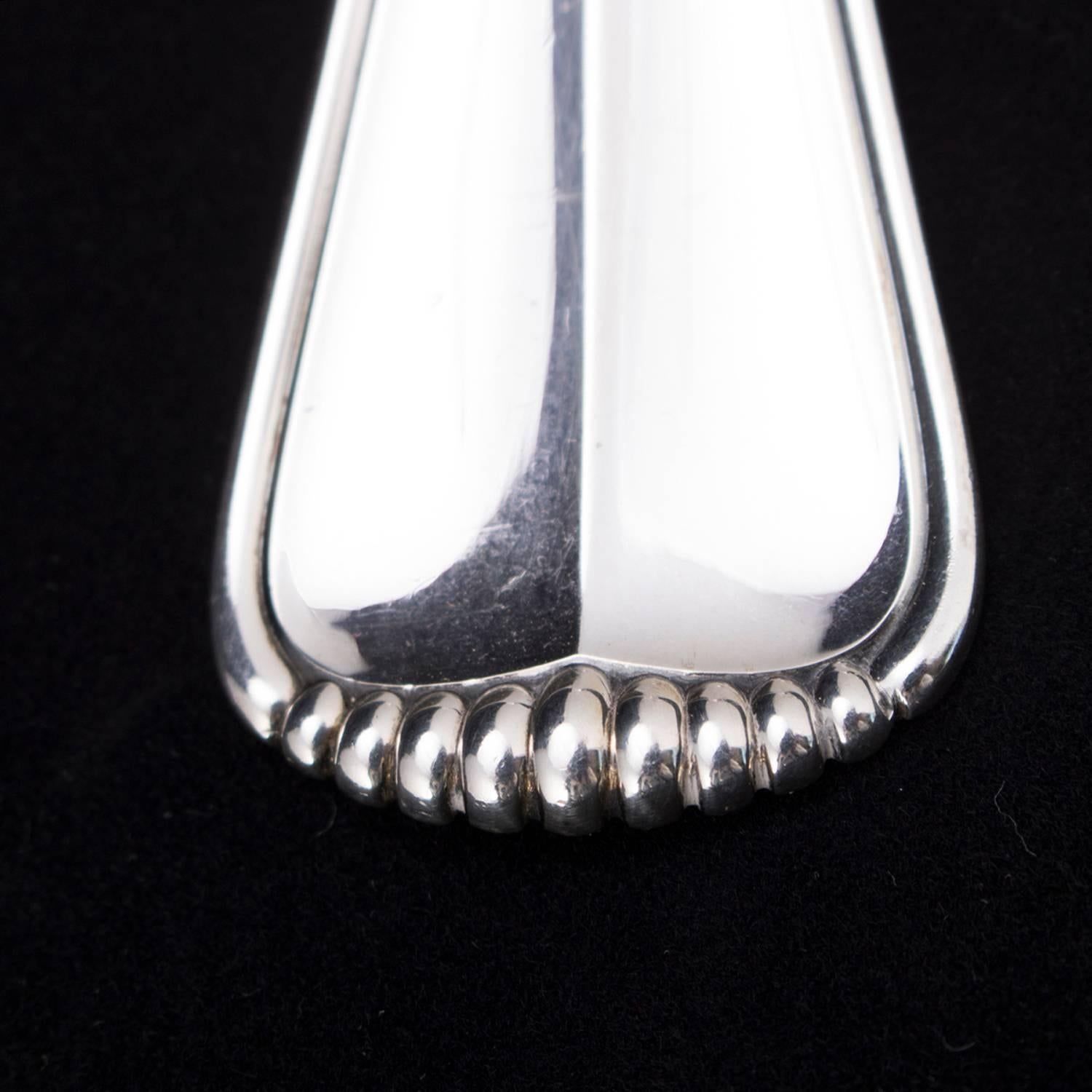 Italian Buccellati sterling silver serving spoon in Milano pattern features faceted handle with beaded crest, en verso 