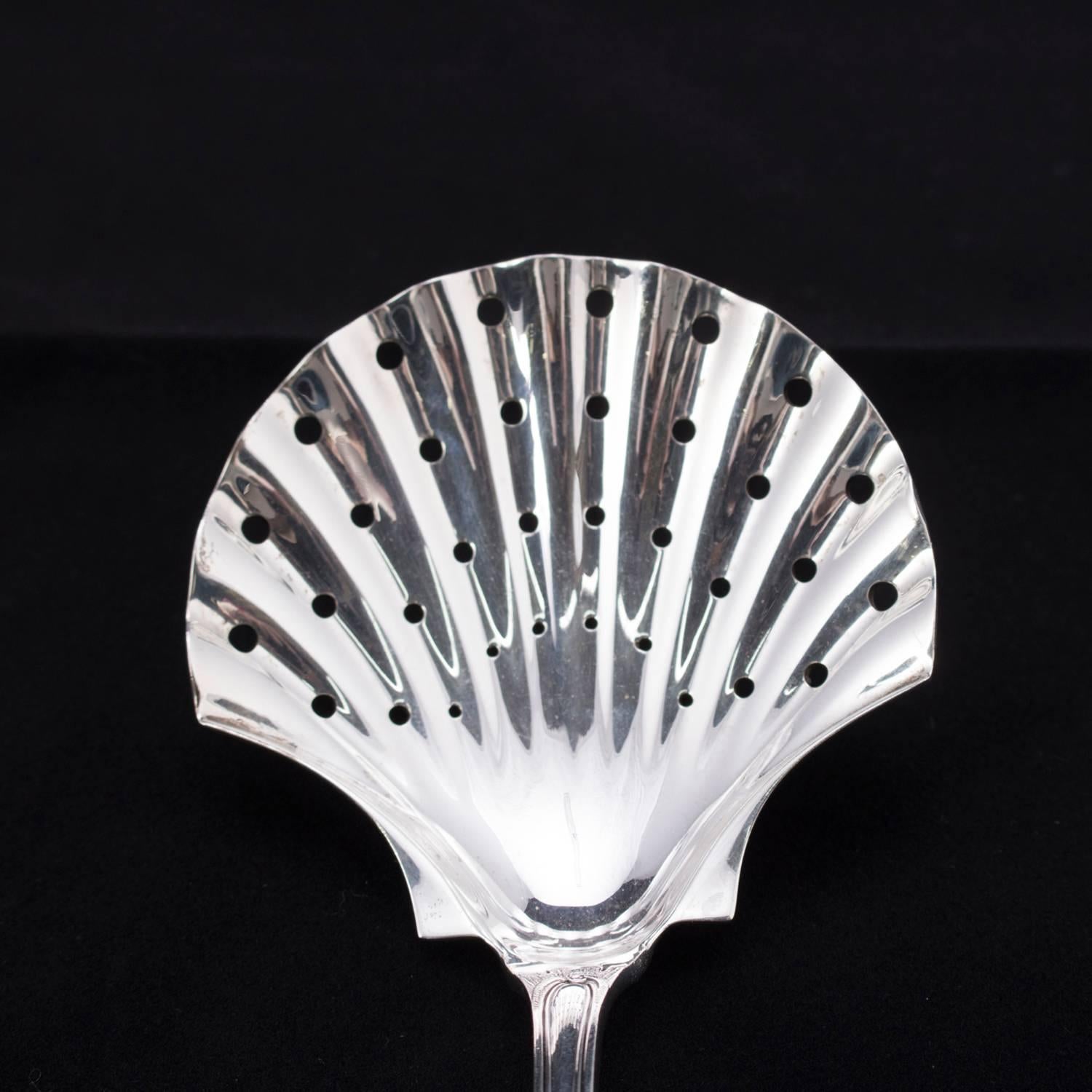 Italian Buccellati sterling silver strainer in Monte Mario pattern features pierced shell form bowl, scroll and foliate decorated handle, en verso 