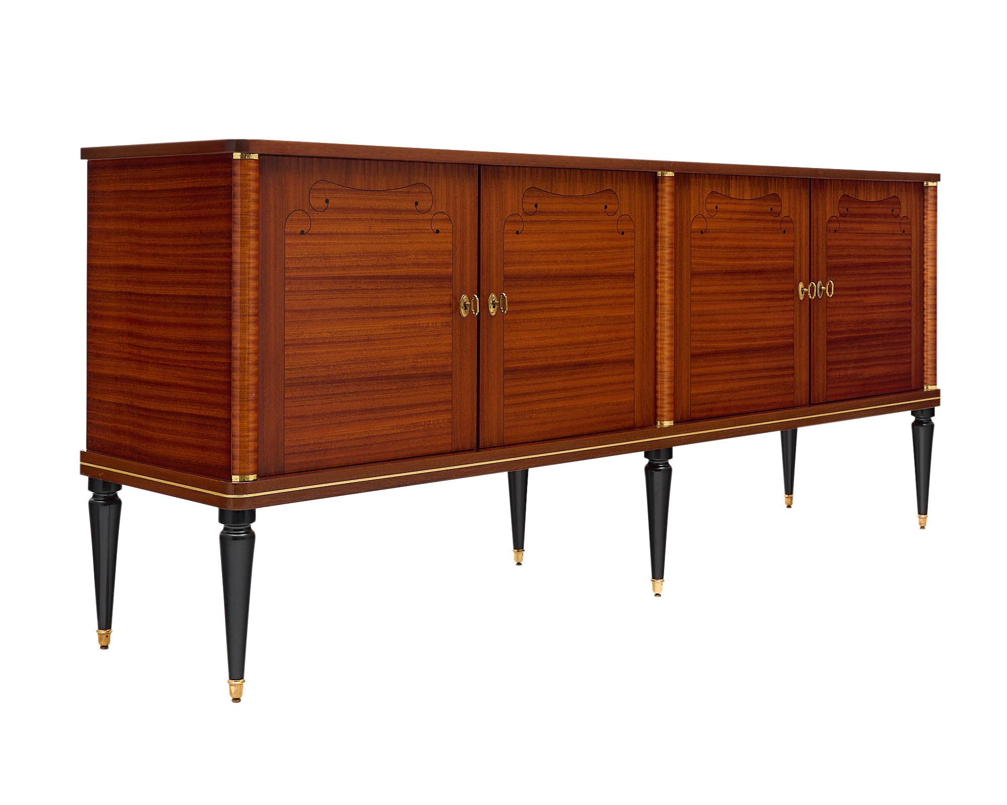 Buffet/enfilade, Italian, made of rosewood and burled rosewood, adorned with a delicate ebony inlay. The credenza features three half columns with brass hardware and fine trims throughout. The four doors open up to a satinwood interior with