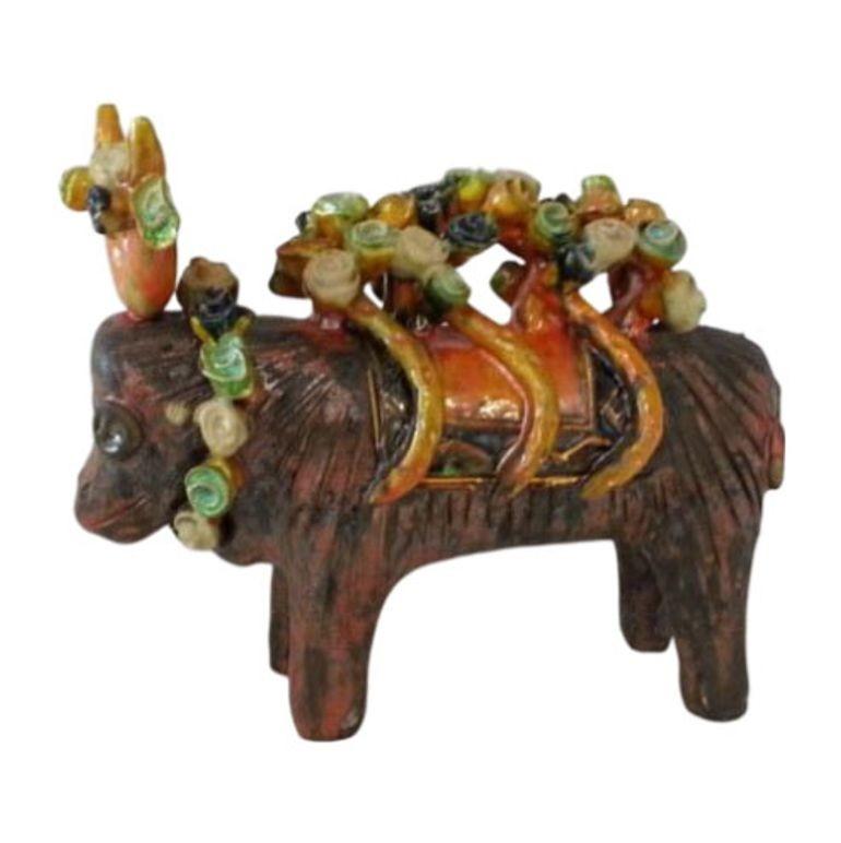 Dieser Stier aus Ton wurde in Italien handgeformt. Der Körper des Stiers ist in matten Braun- und Rottönen gehalten, während der Sattel und die Girlanden in Schwarz, Gold, Grün, Rot und Gelb glänzen.

Auf dem Fuß befindet sich ein Aufkleber Made in
