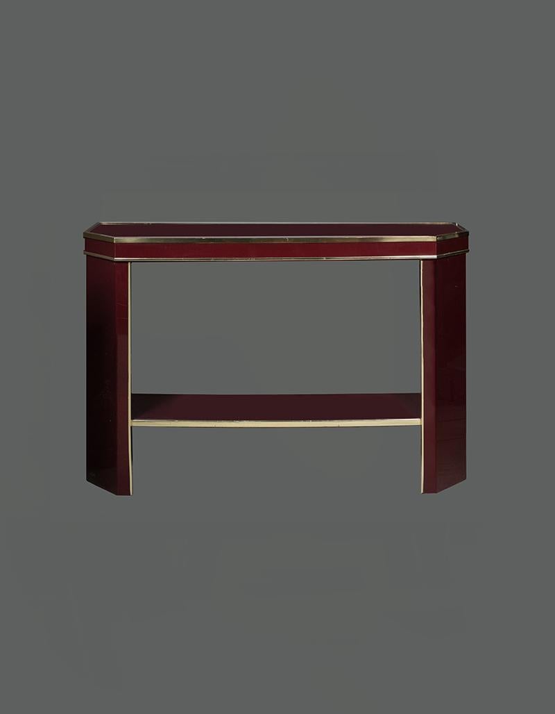 Italian Burgundy lacquer and brass console table with matching mirror, brass edges, glass cover top. The octagonal mirror measures cm 75.5 x 75.5.
 