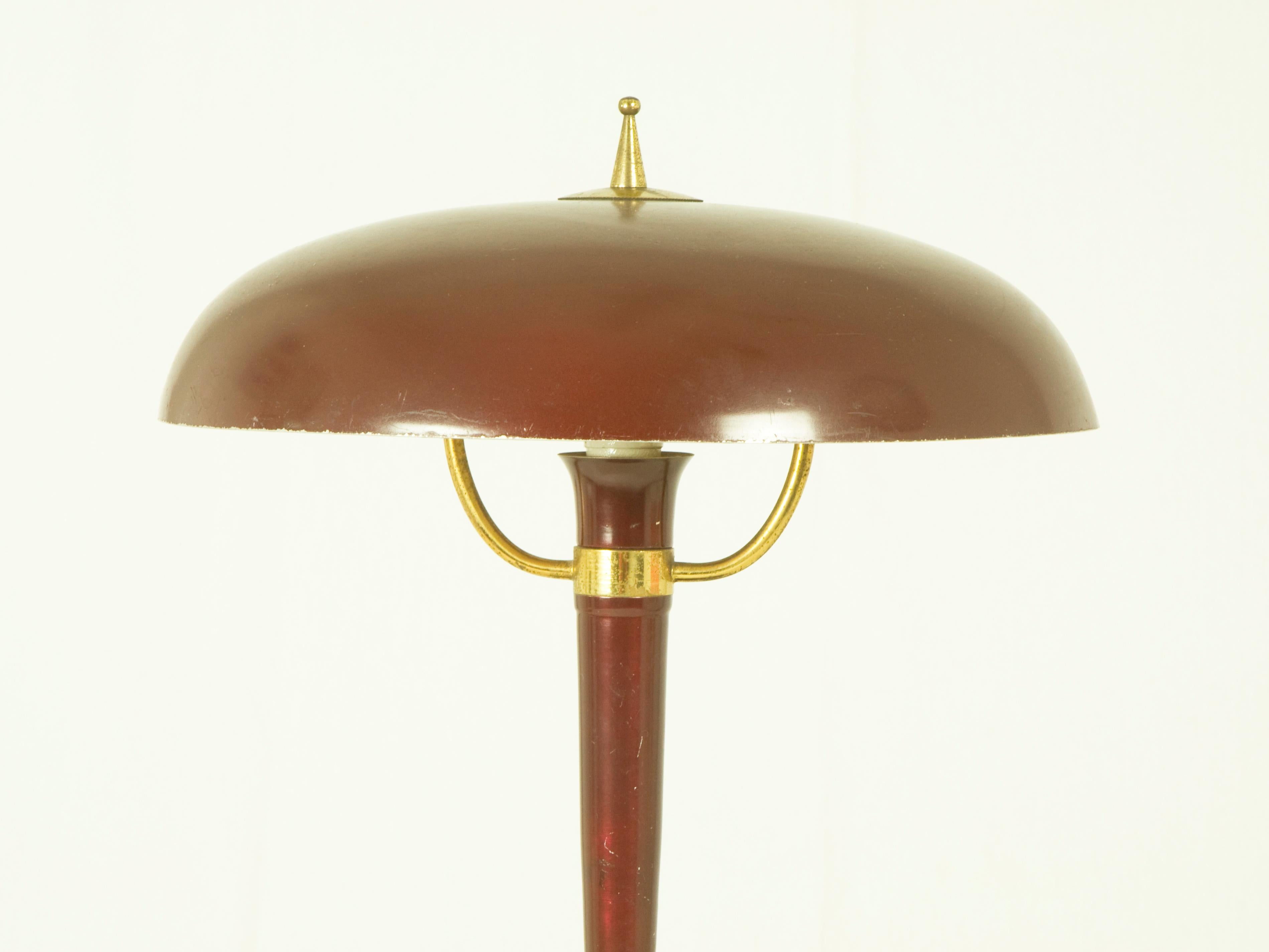 This table lamp was produced in Italy around the 1950s. It is made from painted metal, cast iron and brass. It remains in very good vintage condition with its original electrical system.