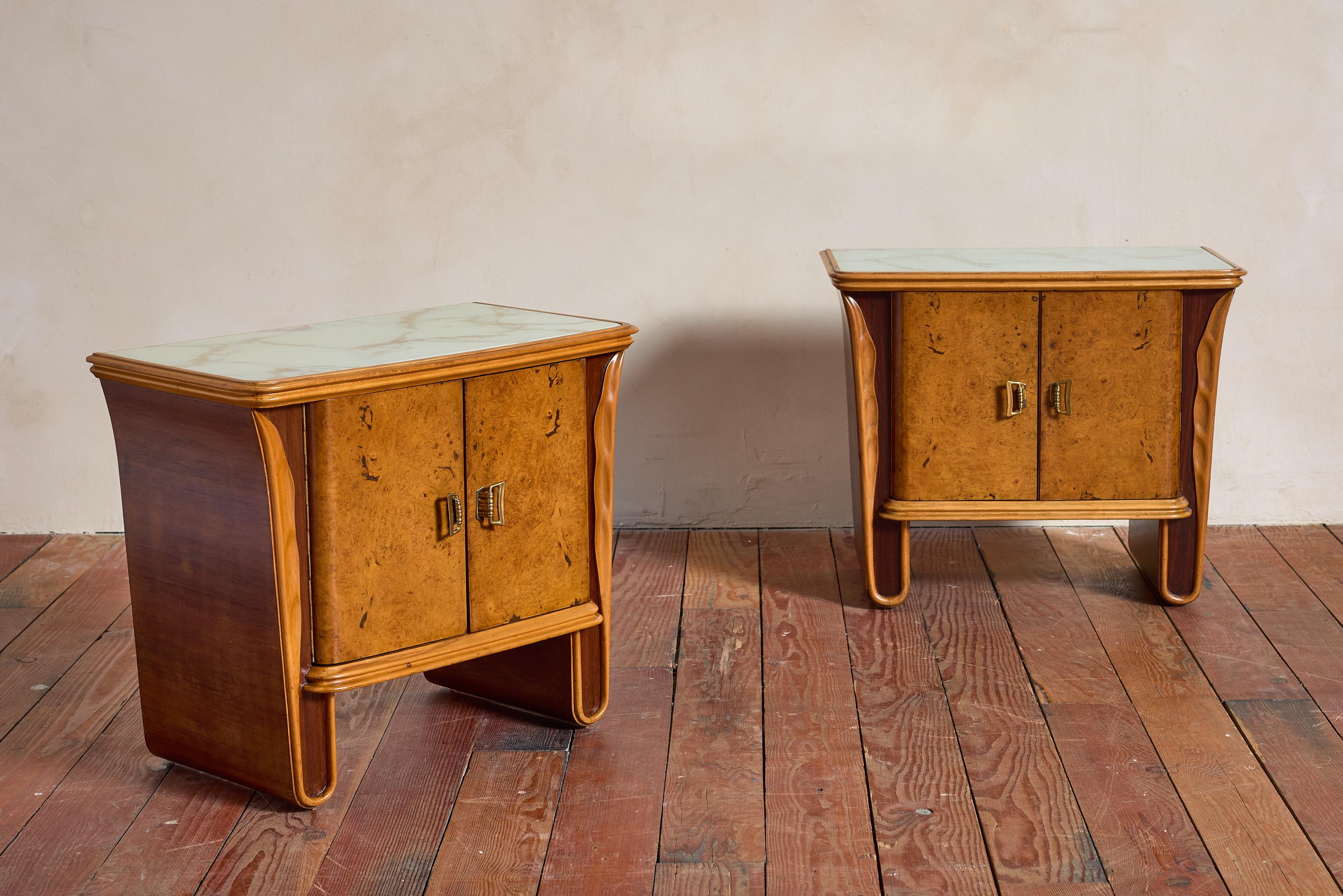 Pair of Burl Wood End Tables, Italy 1950s

Crafted from thuja burl wood with mahogany accents and brass hardware. 

Glass tops feature a decorated faux marble surface. 

Wonderful pair!