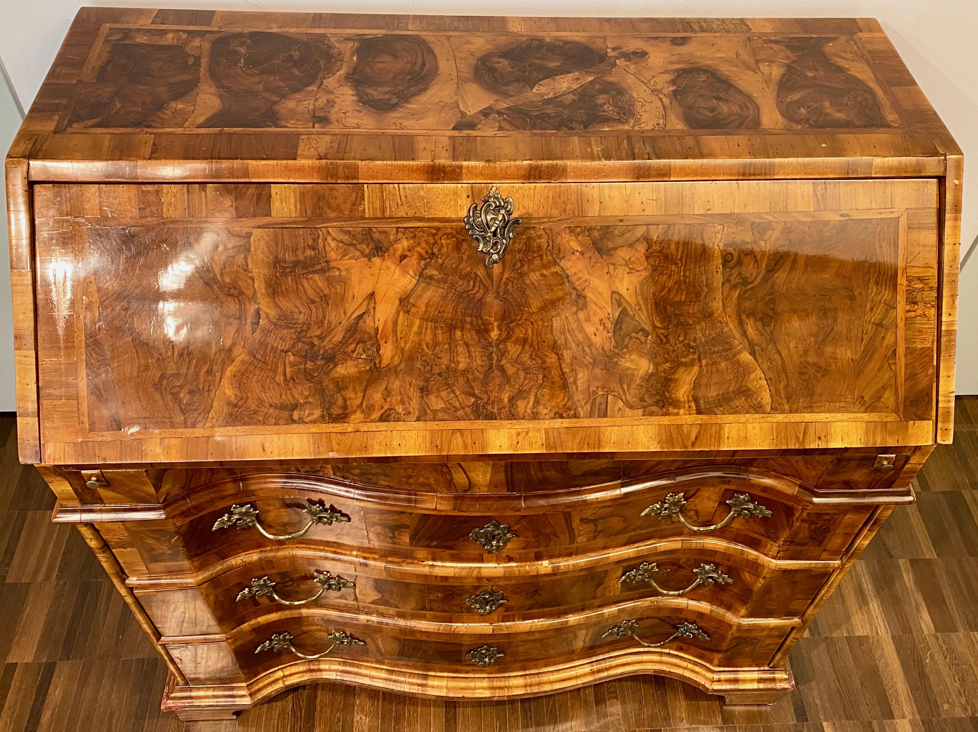 Italian burl walnut Venetian Rococo slant front desk, 18th century.

A Louis XV period walnut and burl walnut veneered Bureau. The inside of the slant front desk is fitted with one drawer on each side of a central door and a secret compartment on