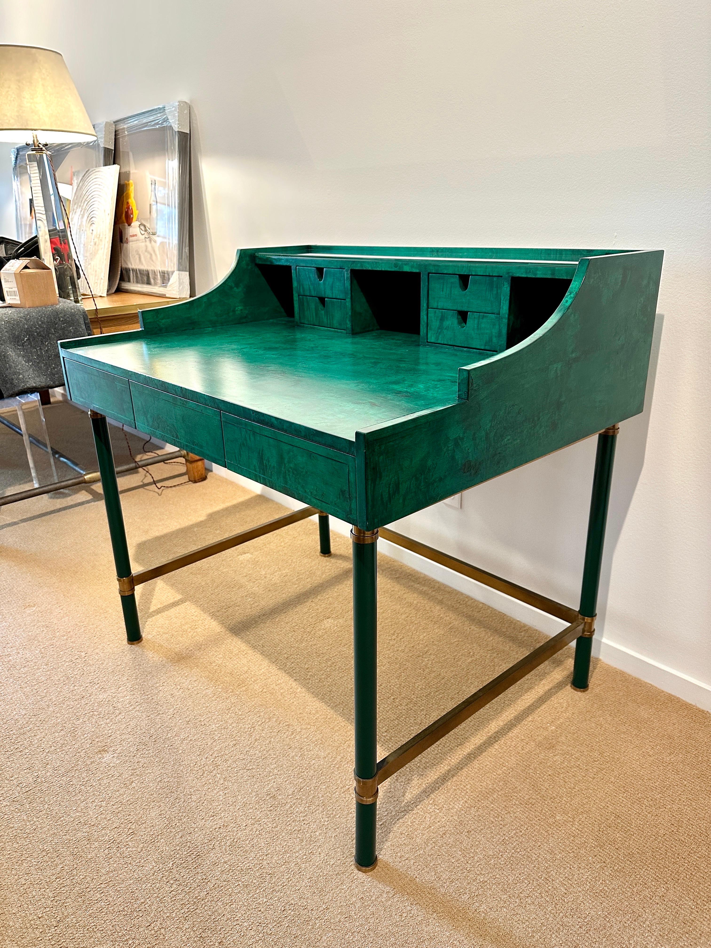 This magnificent malachite green stained burl wood desk with small drawers and ample writing space, sits atop a metal frame with brass stretchers. It is Italian and possibly made by Aldo Tura. Writing level height is 30.75 inches tall. It is
