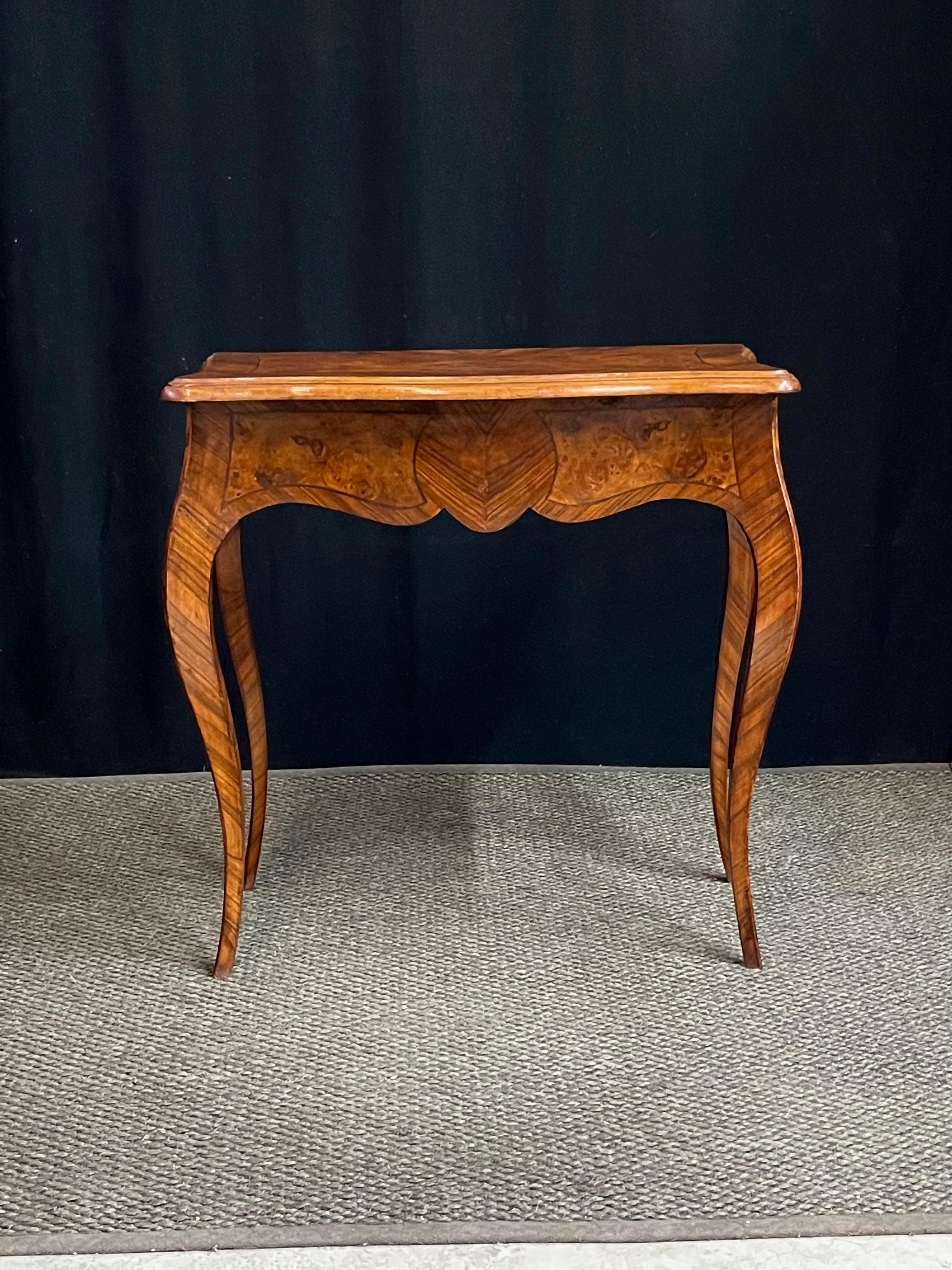 Elegant 20th Century Italian serpentine front console table with a beautifully scalloped apron and exaggerated cabriole legs. The table is veneered in burled walnut inset by ebonized string inlay and a contrast cross-banding. A very versatile piece
