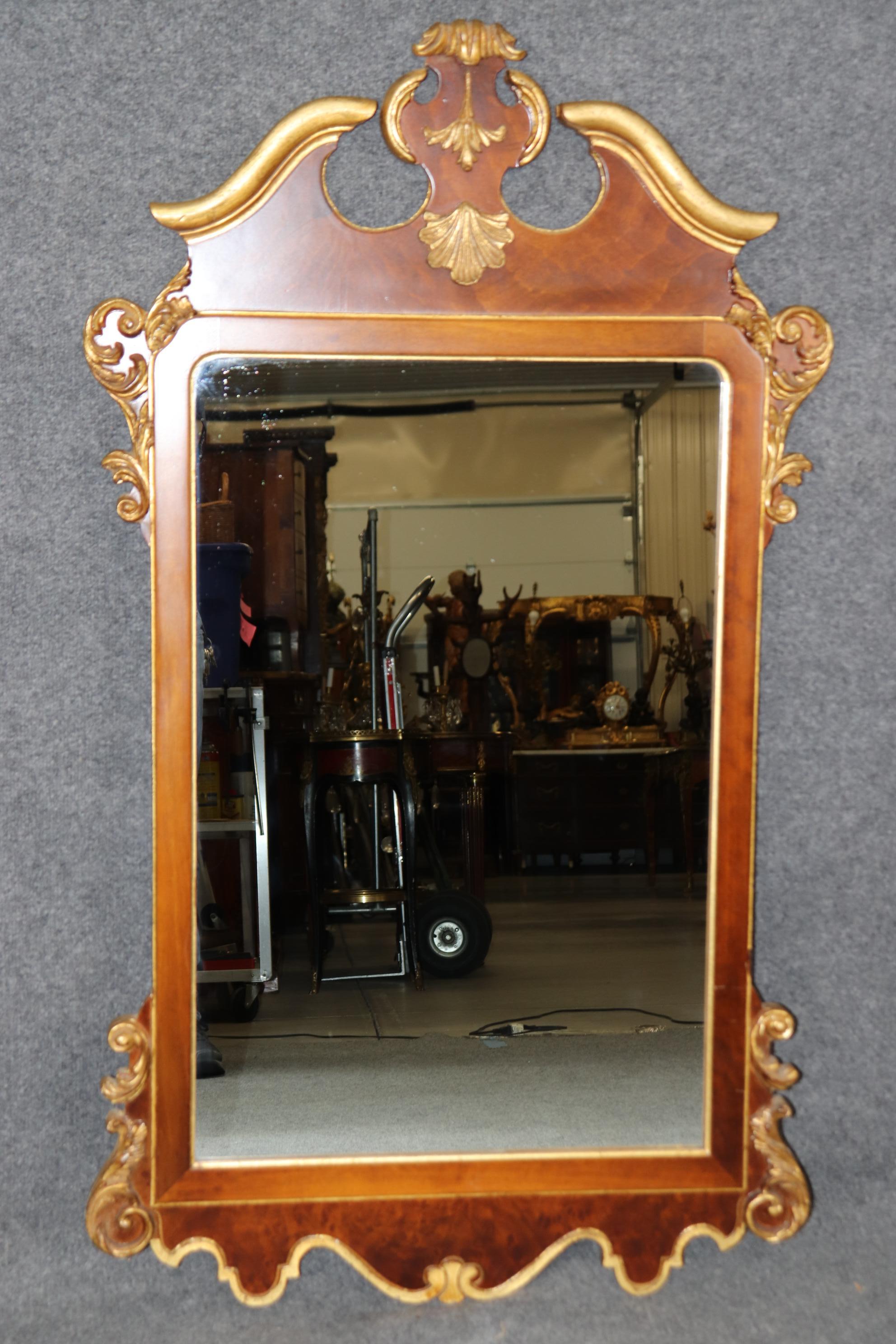 Dimensions - H : 49 1/4 in W : 28 1/2 in D : 2 in 

Ce miroir italien sculpté en noyer ronce et or doré est un exemple étonnant d'artisanat raffiné, combinant la riche élégance du noyer ronce et l'opulence des accents d'or doré. Le grain de bois