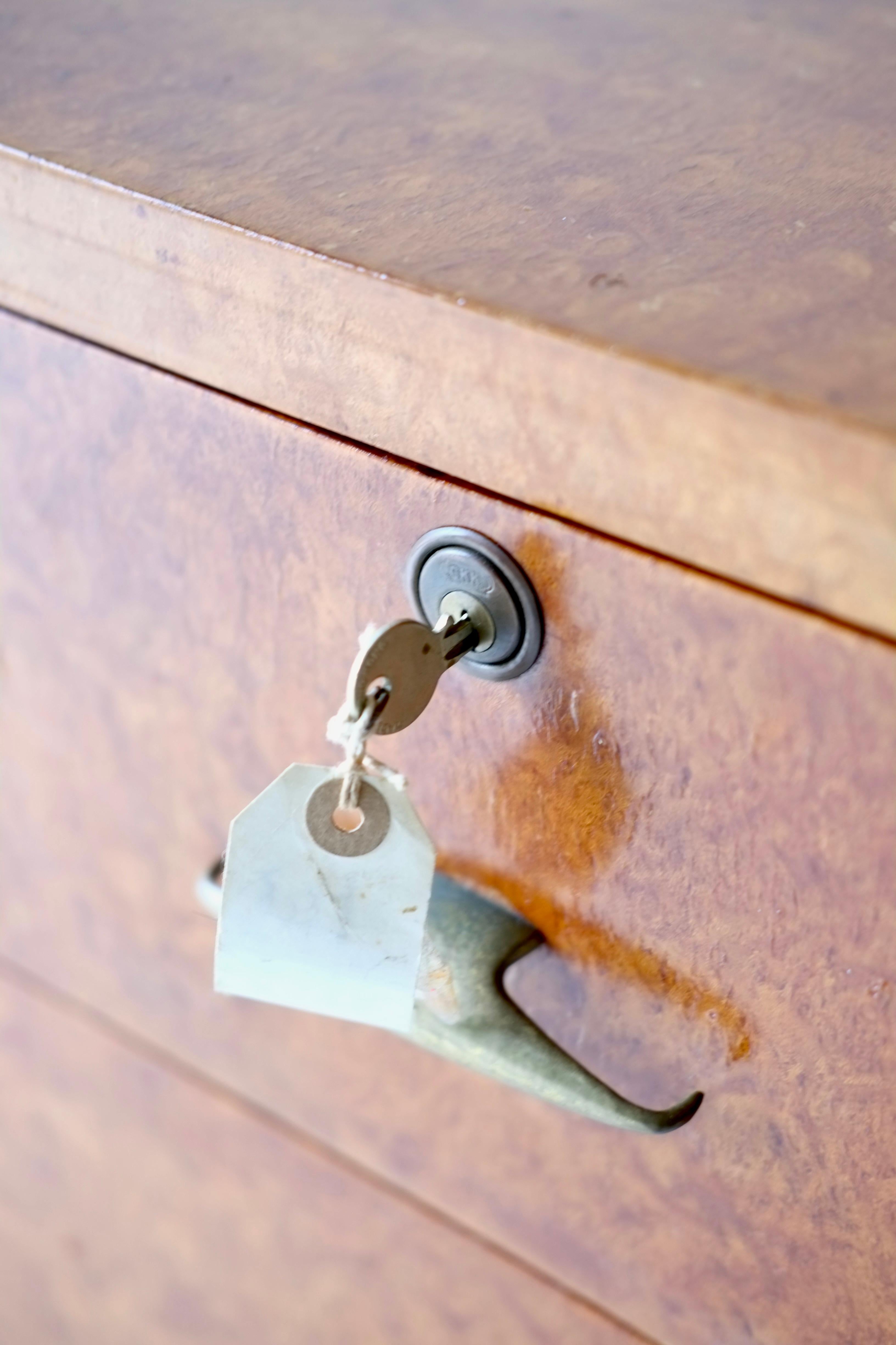 A Eucalyptus burr wood chest of drawers.

Italy, circa 1950's. 

In good overall condition, with all drawers and locks working as they should and three keys present. 

H 93 W 210 D 57