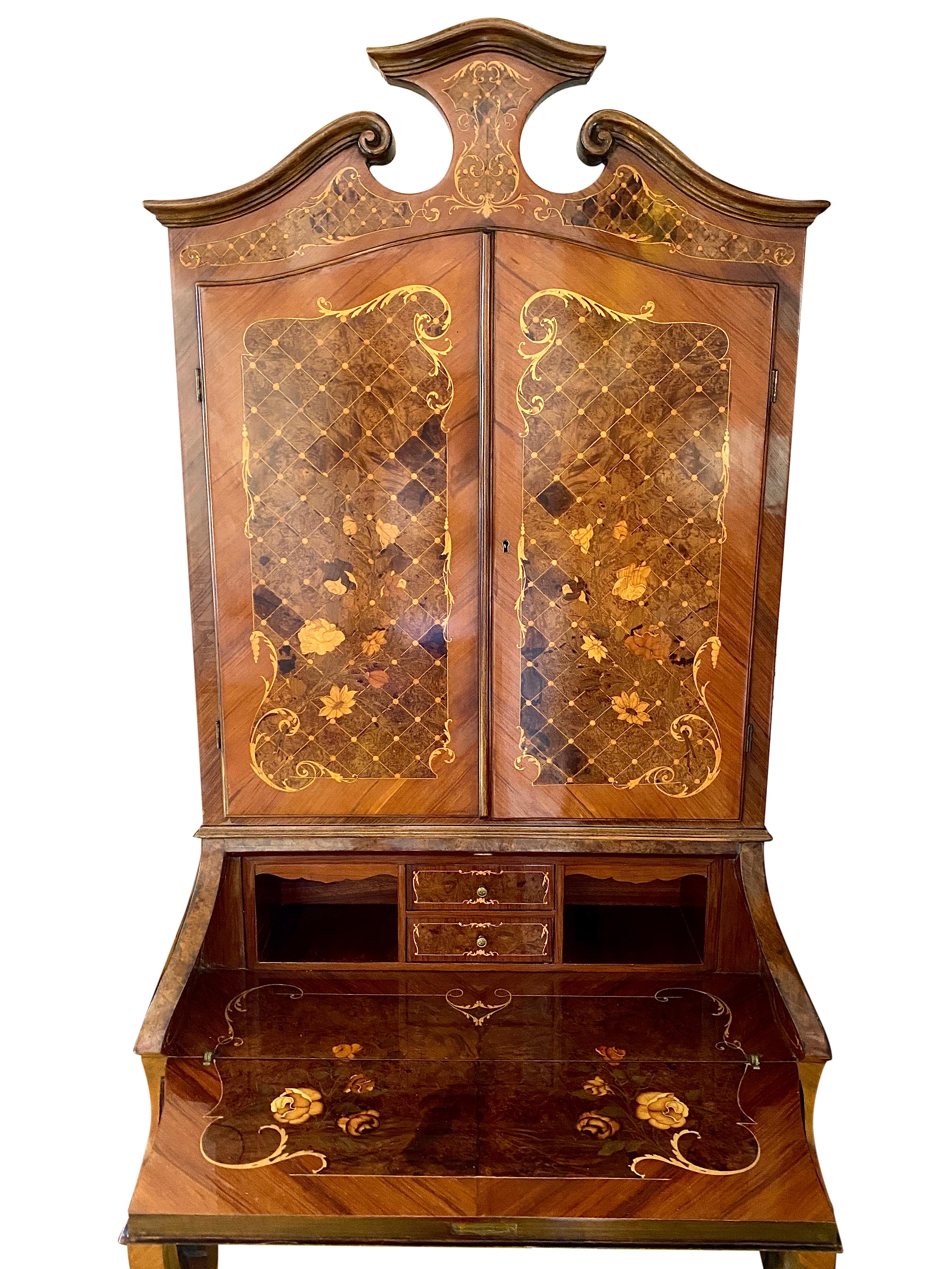This Italian Satinwood Secretaire is very elegant with exquisite detailing over the entire piece with marquetry inlay. It features an Italian broken pediment, delicate Cabriole legs, and Ormolu feet. There is some subtle wear on the veneer of the