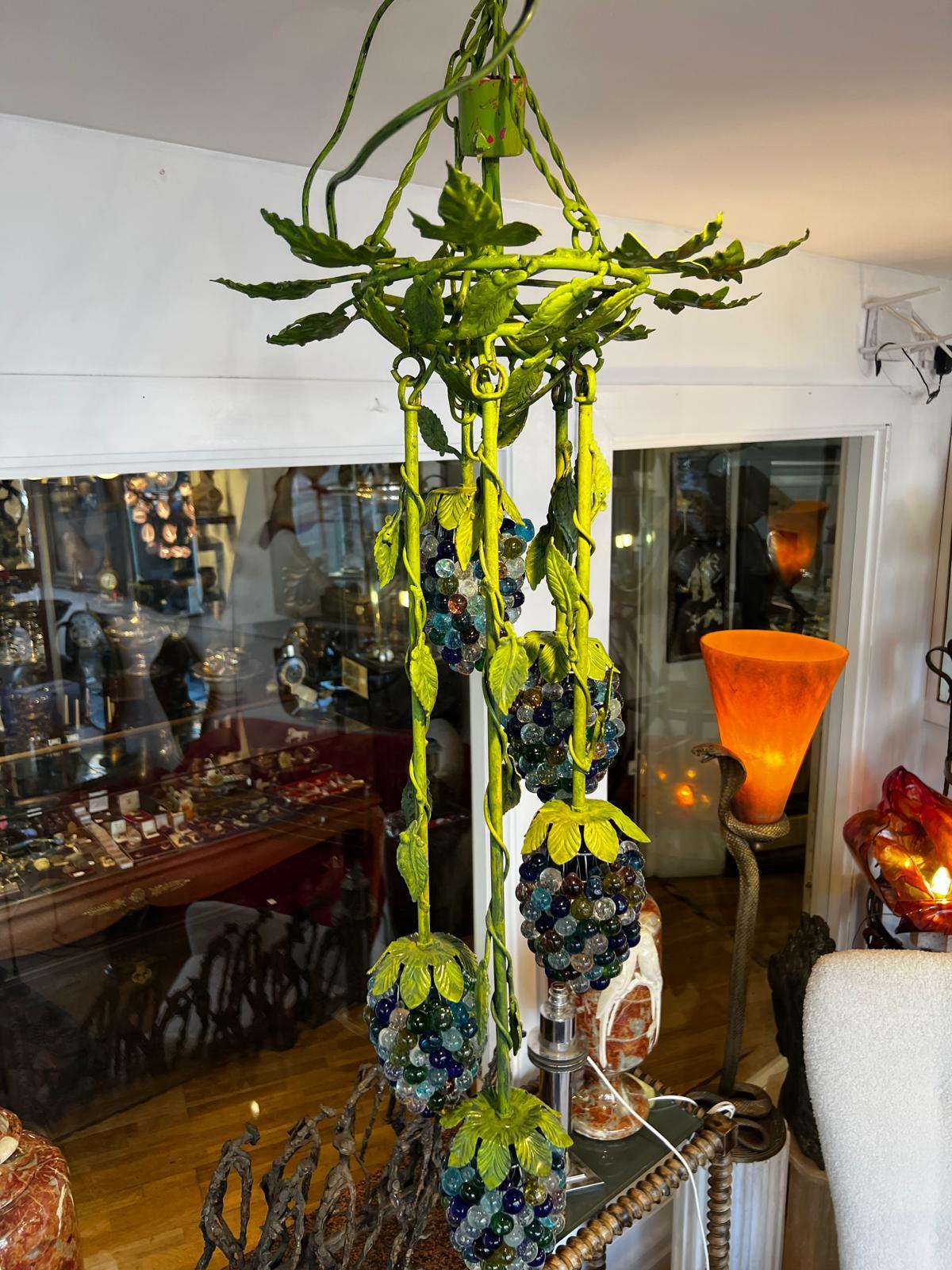 Lustre italien des années 1960 de Cesar Toso en forme de vigne avec des raisins en verre coloré faits à la main et montés sur un treillis et des feuilles sur un échafaudage de fer émaillé vert et de vrilles en fil de fer. Cinq grappes de