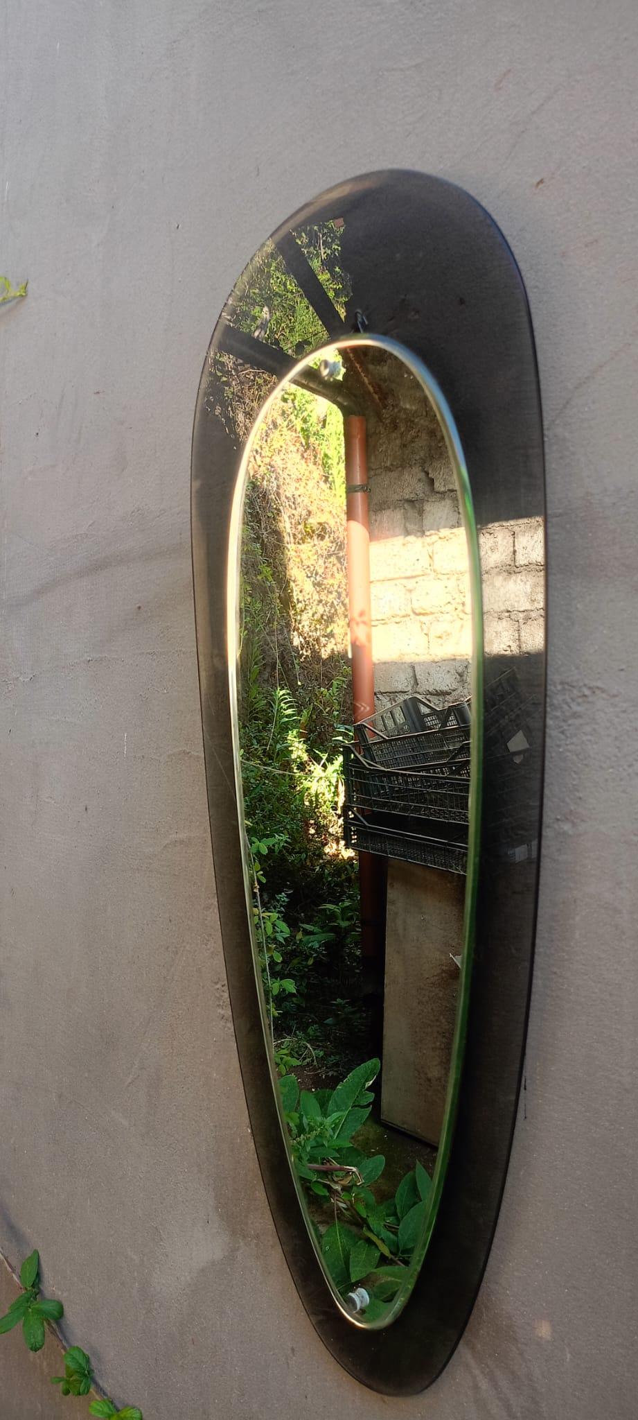 Italian 1970's wall mirror attributed to Crystal Art, with a brown smoked glass frame and two decorative chrome screws  