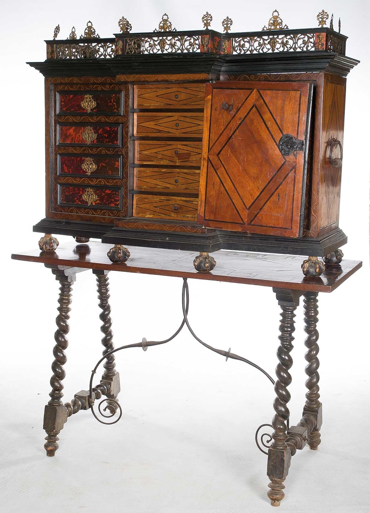 Italian bargain on table. Walnut wood and rosewood, hawksbill, bronze in color and gilded, 17th century.
Uncovered sample desk located on claws with ball and with handles on the sides. The front presents the central part advanced with chapel; and