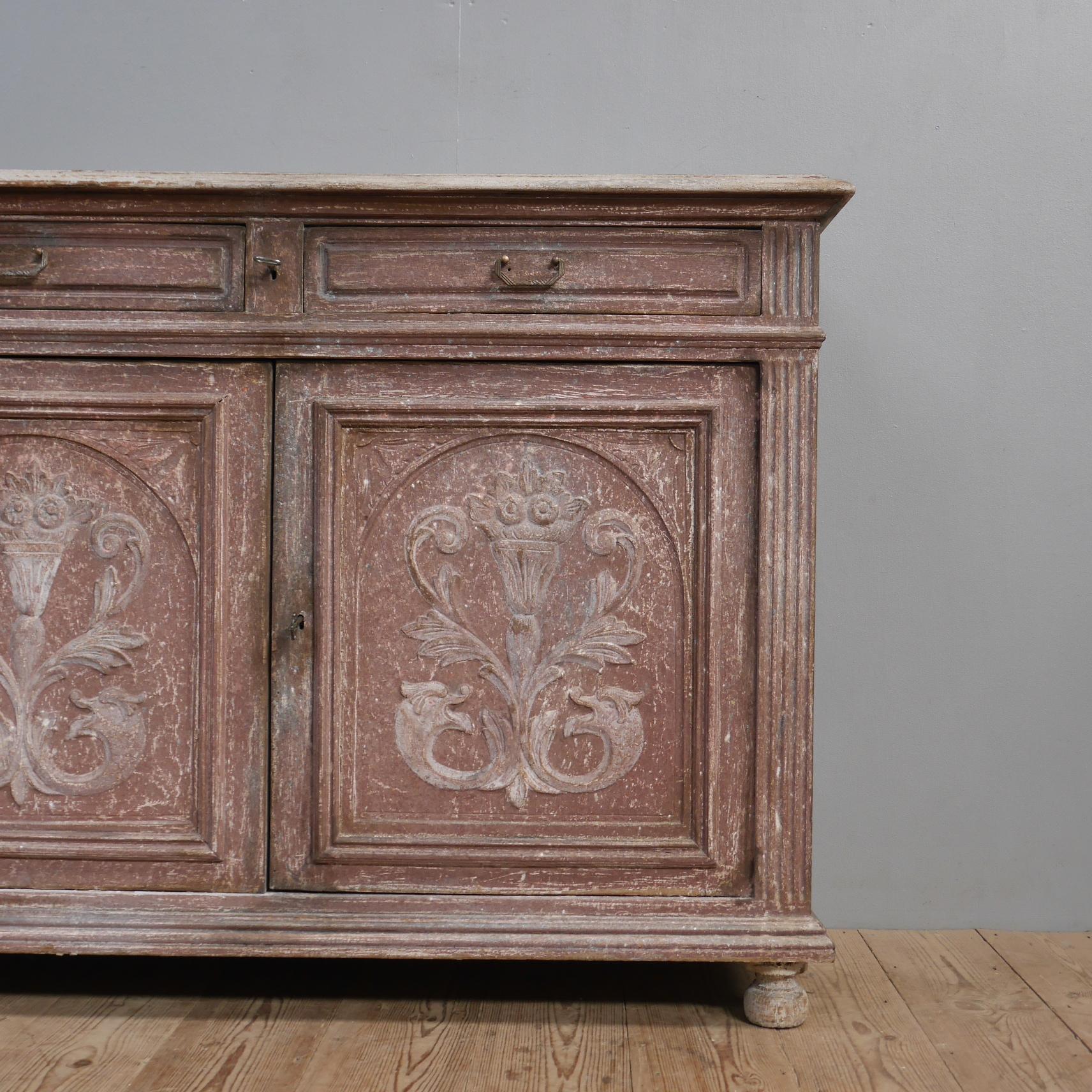 A painted Italian cabinet.
A wonderful piece of furniture in the most remarkable layered & distressed paint. Raised on turned feet, the two door cupboard sits below two shallow drawers with an unusual locking mechanism & working key. The door fronts