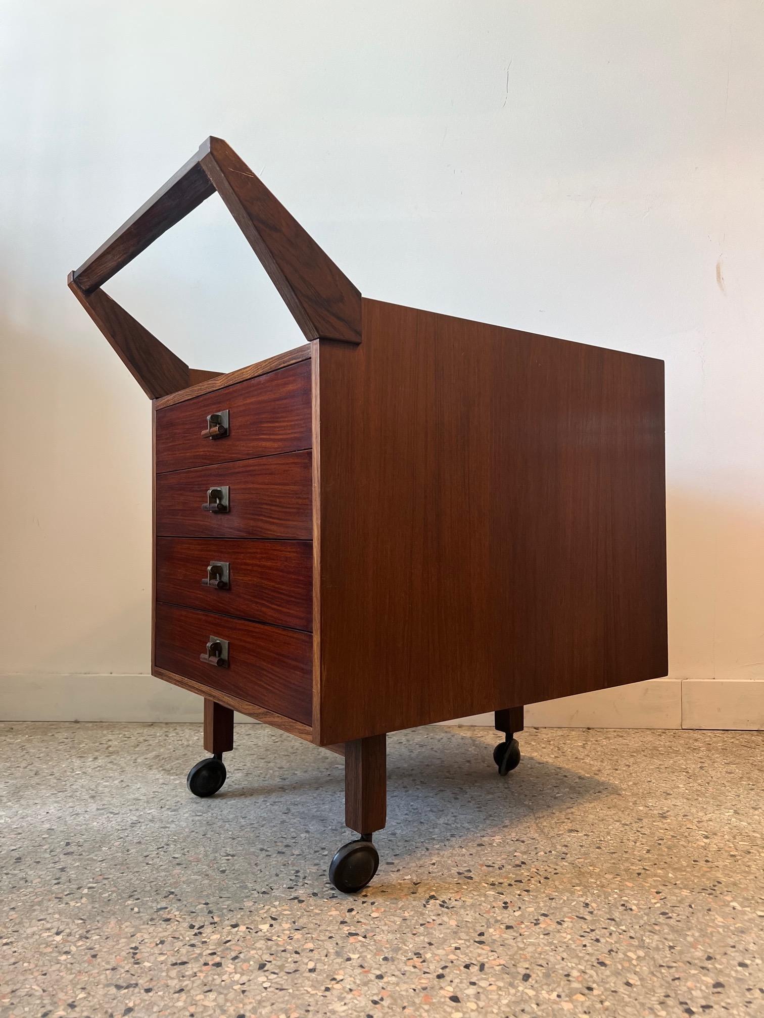 Unusual and rare filing cabinet or chest of drawers with an exaggerated handle-rosewood. On three legs with casters-four drawers.  Model # C24  designed by Franco Albini and Franca Helg for Poggi ca' 1958. 