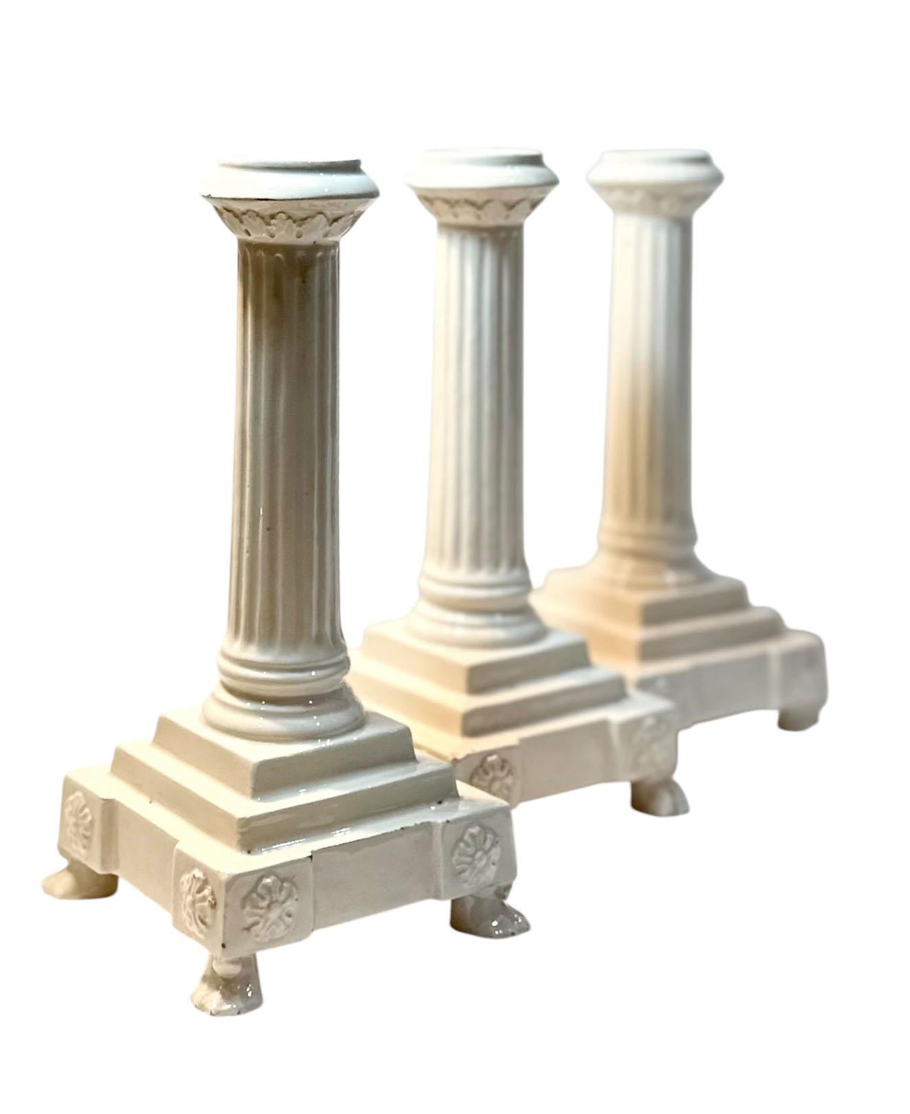 A set of three very attractive ceramic candle holders from Italy in the form of columns. Sitting on paw feet. Circa early 19th century.