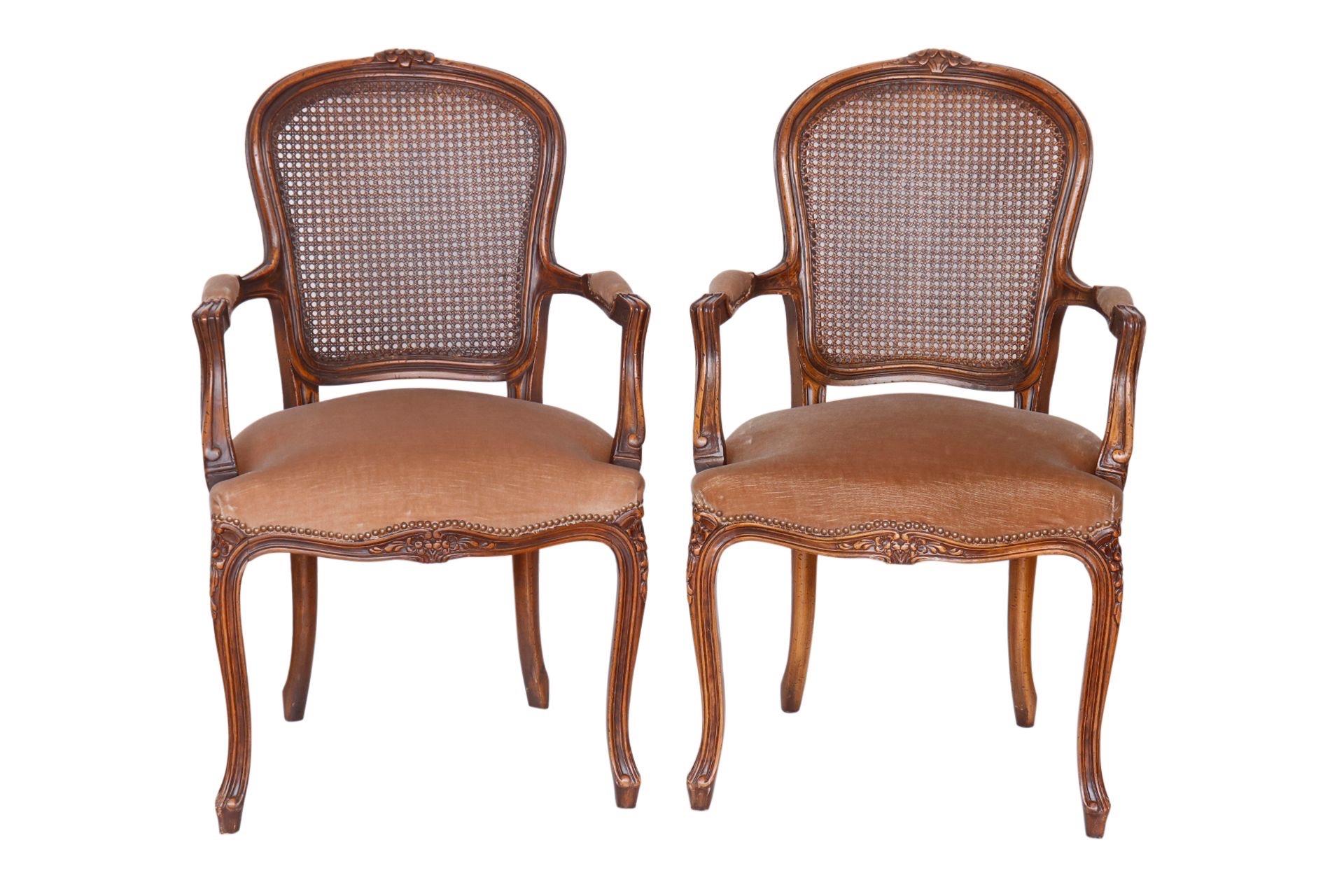 A pair of Italian fauteuils made by Wernermeier Enterprise Inc. Frames are carved throughout with little flowers on top of the crest rail and outward flared arms with cushioned hand holds. Seat backs are caned and horseshoe shaped seats are covered