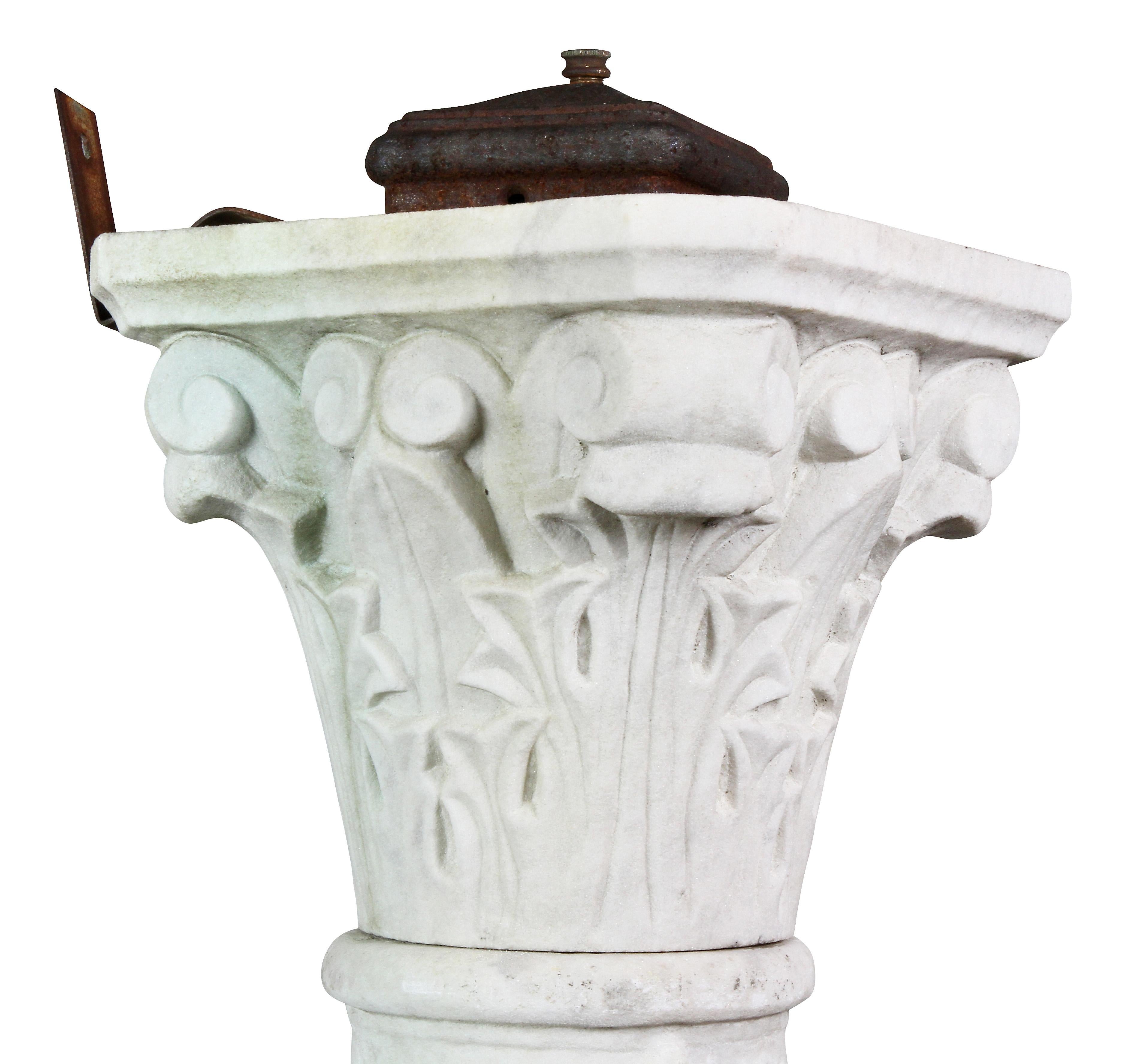 Originally used in a garden and was electrified. Stylized Corinthian capitol with the remains of an old metal switch box, grape and grapevine carved column, square stepped base.