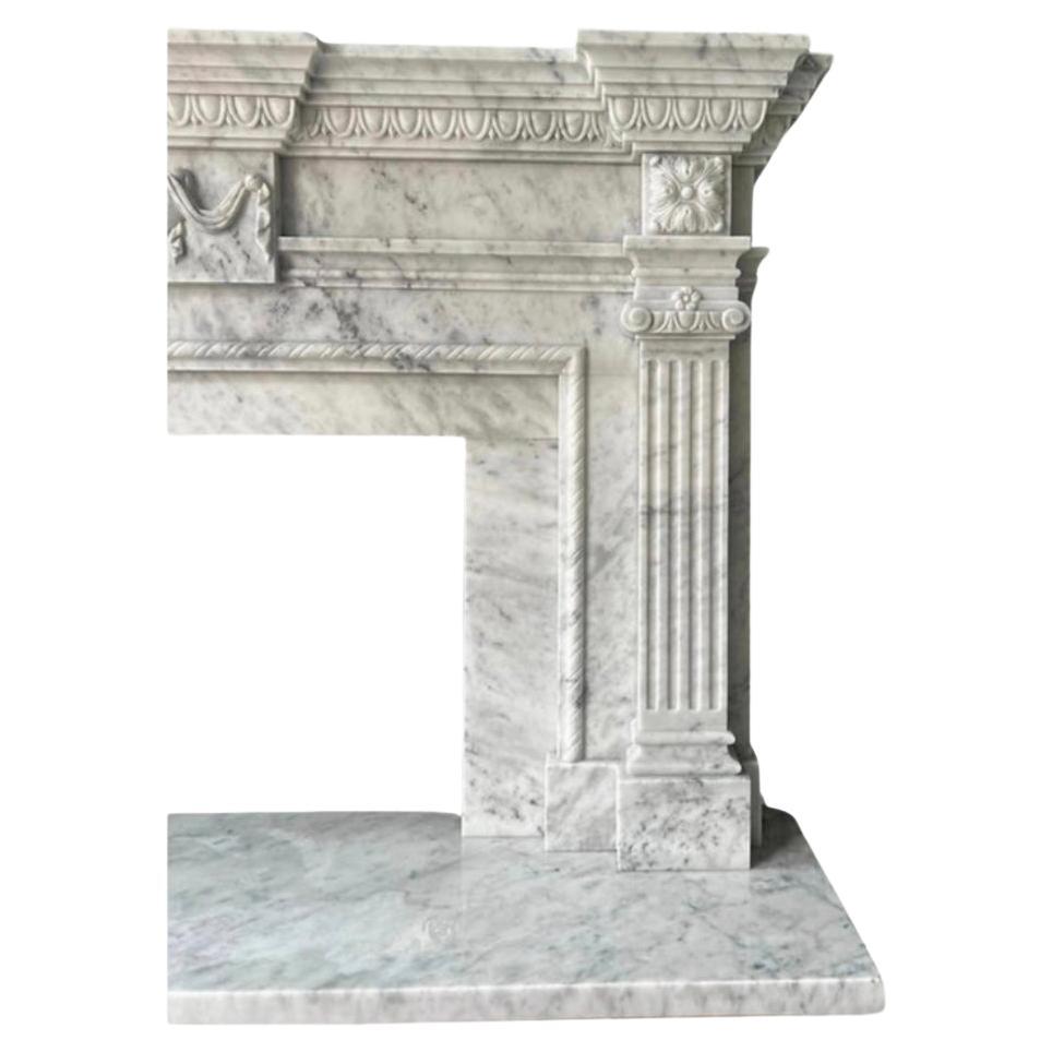 Esta repisa de chimenea tallada en Carrara italiana ejemplifica el lujo y la artesanía fina. Fabricada en mármol de Carrara de primera calidad, famoso por su elegante tono blanco y su sutil veteado, la repisa presenta intrincados detalles tallados a