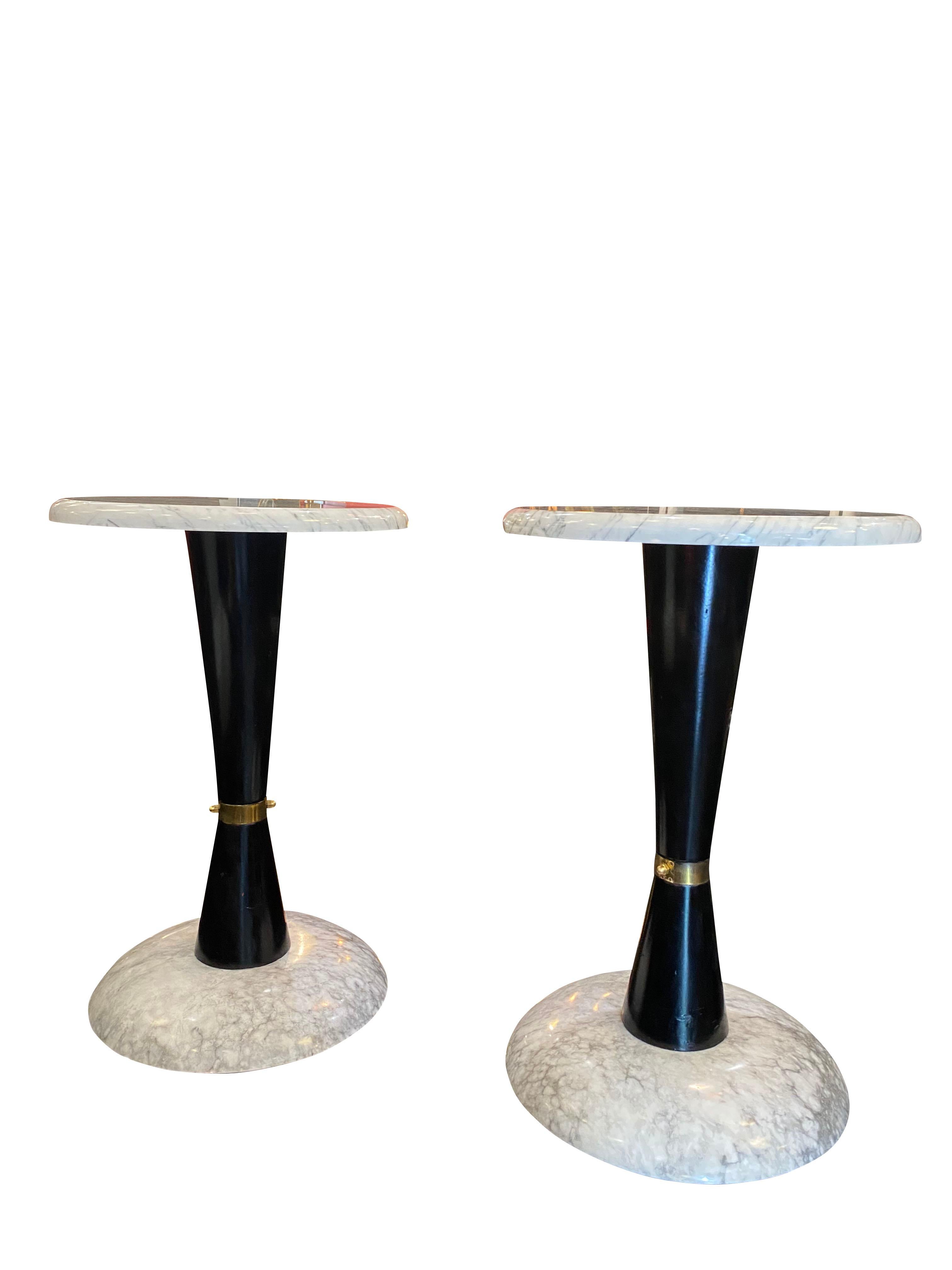 An imposing pair of 1950s side tables in Italian Carrara marble standing on black lacquered wood with brass detailing.

  