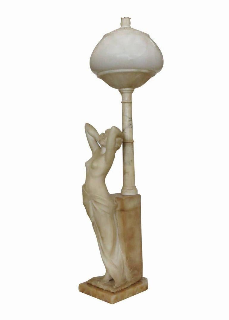 Finely carved early 20th century Italian lamp in alabaster, featuring a beautiful Greco-Roman nude female figure standing beneath an elaborate lamp shade, decorated with carved and incised flowers and garlands.

Signed Italy, circa 1905.
 