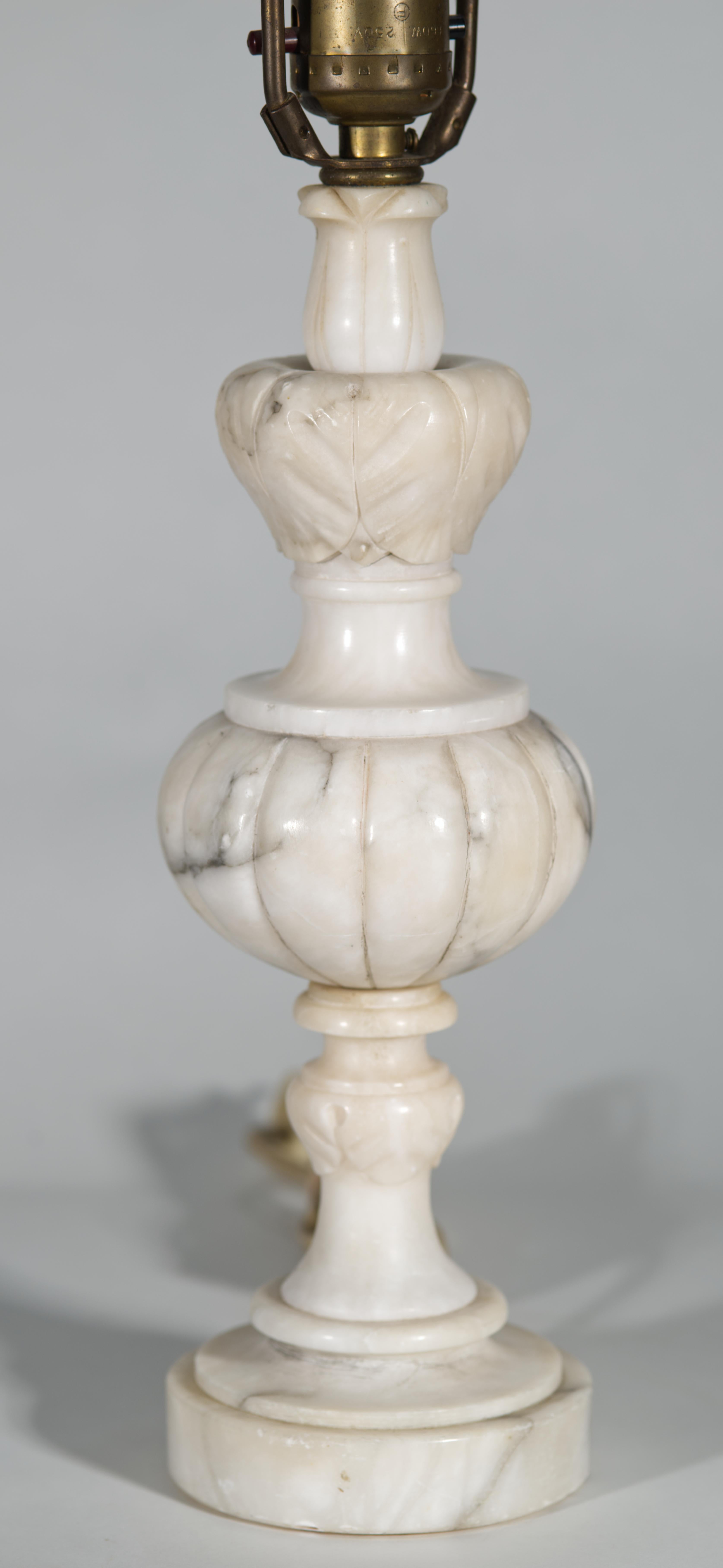  Vintage Italian hand-carved Alabaster accent or table lamp features baluster urn form with a wreath of leaves (most probably acanthus leaves) accentuating the top of the urn. The body of the lamp is decorated with carved leaves motif and mounted on
