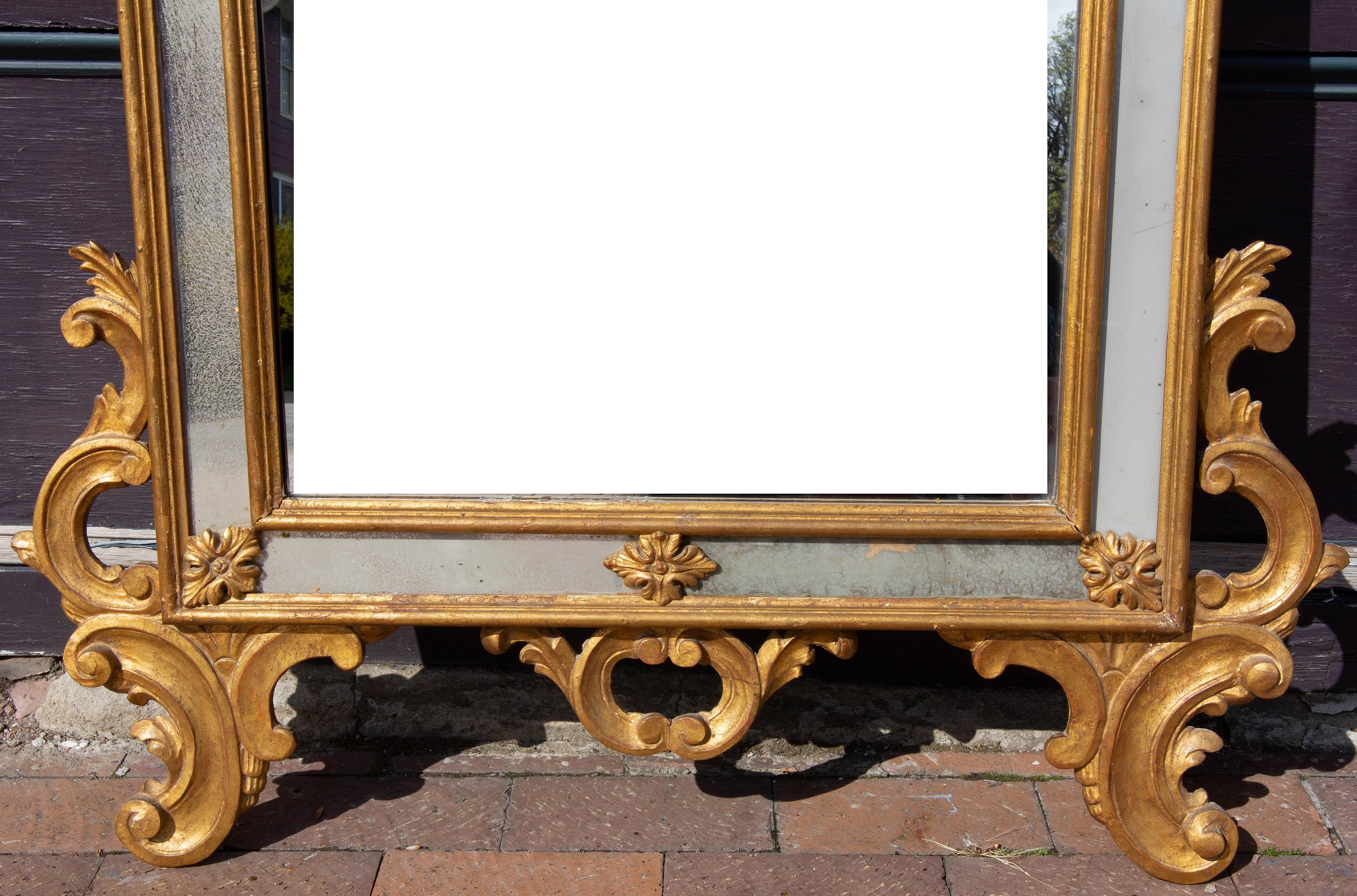 Large Italian gilt wall mirror. Mirror center panel with antiqued opaque side panels, mid 20th century. Measures: 65