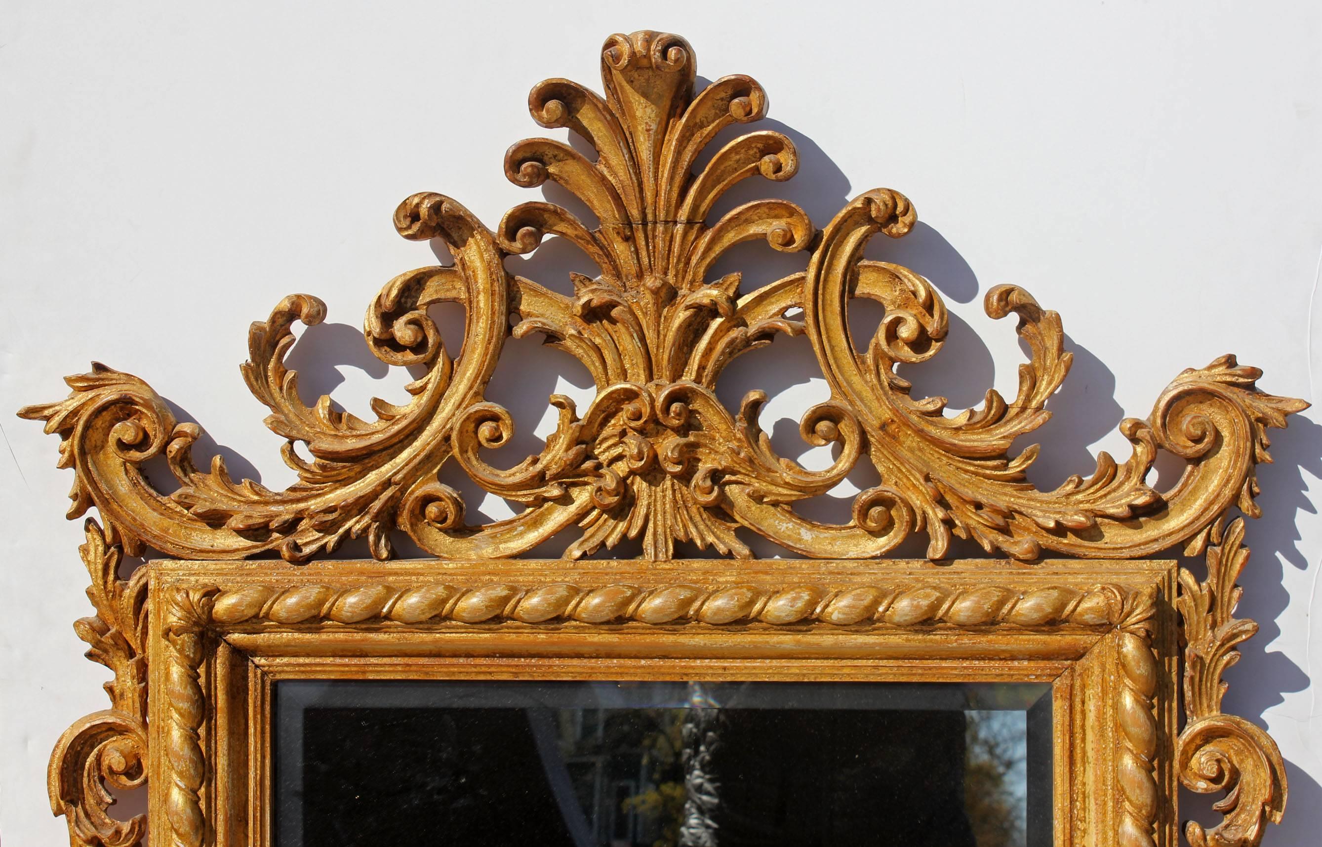 Finely carved and gilt solid wood beveled glass mirror, Italian, neoclassical style. Please, contact us for shipping options.