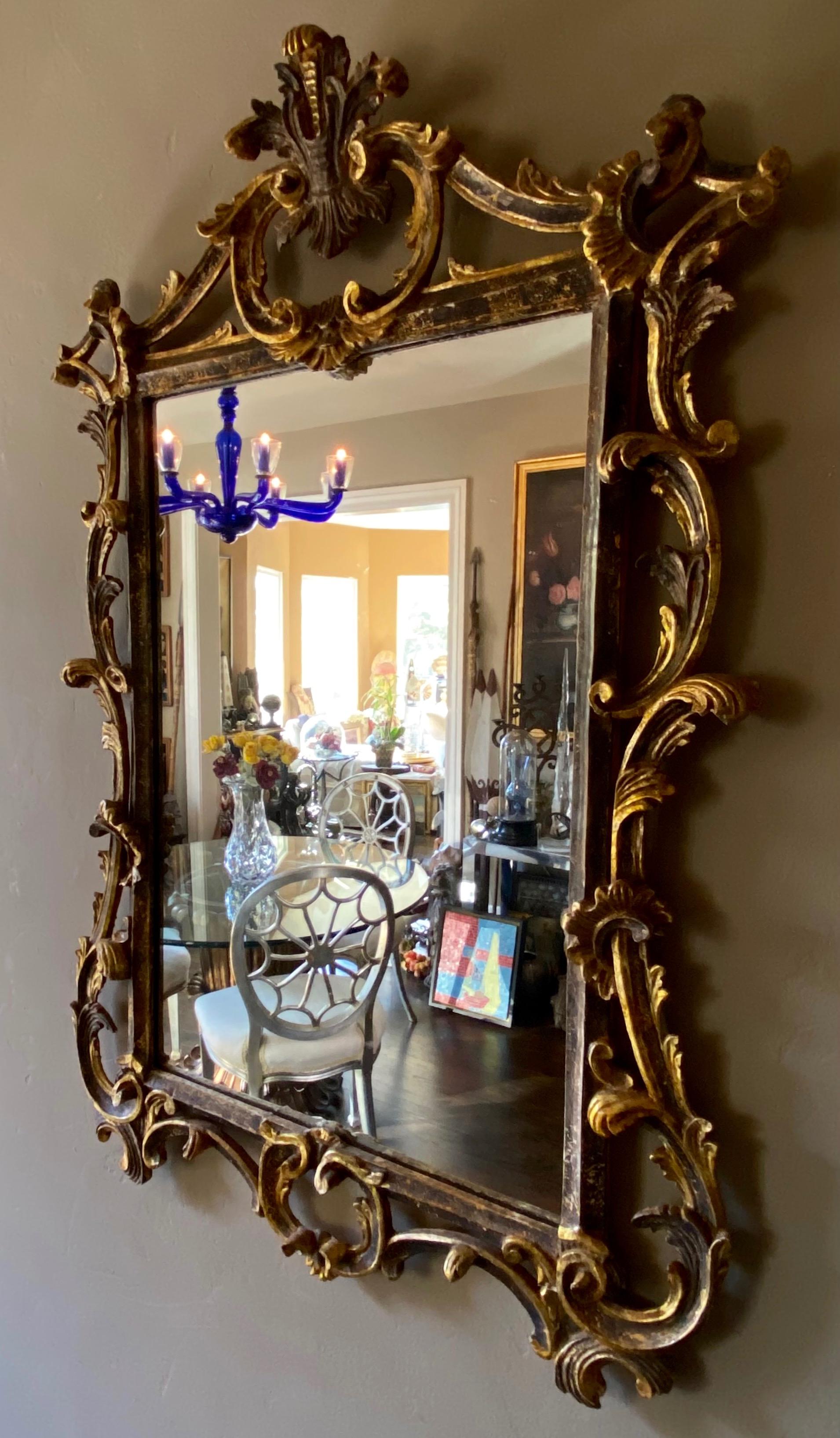 Beautifully carved wood mirror with gold and silver gilding.
Retains warm original patina to gilt wood frame. 
Exceptional fine quality and detail.
Italy, circa 1950.
  