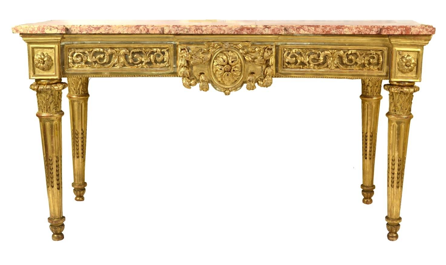 Fine Italian carved and giltwood neoclassical console table, the original marble top (Spanish brocatello) over the apron with a center medallion mounted with a large floral boss and bellflower swags; the inset panels with applied leaves, scrolls and