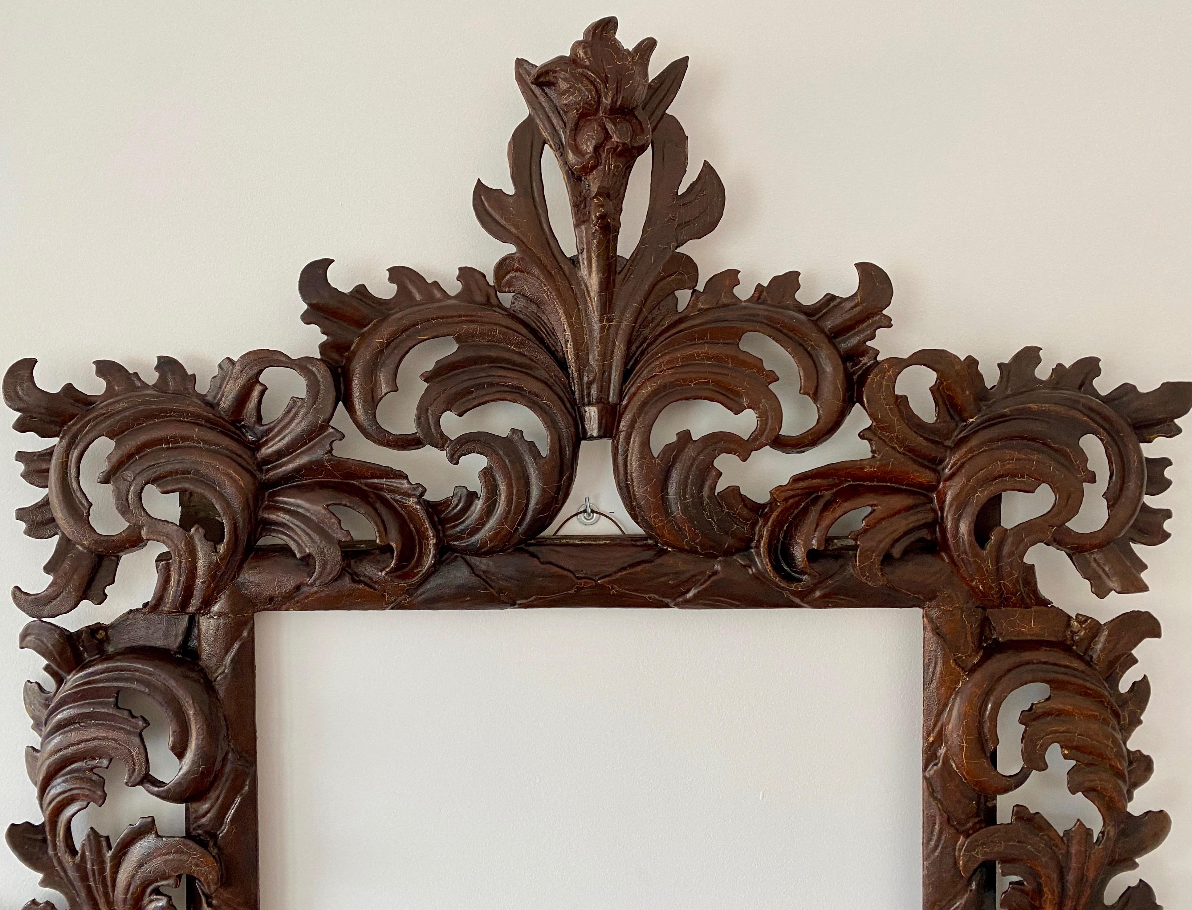 Italian carved and Lacquered picture frame, Circa 1700

This Italian frame was most likely made in Emilia Romagna and more specifically in the town of Modena around the year 1700. Decorated with a flower on the top center and leaves motif around the