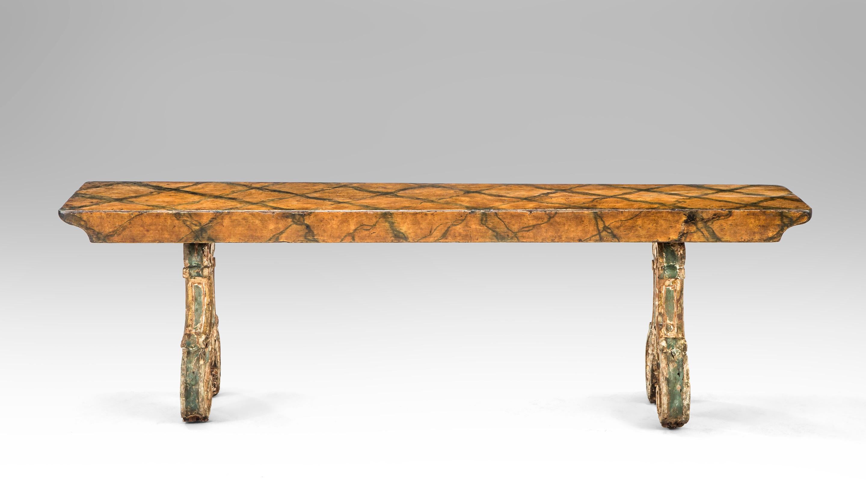 Italian carved and painted wooden bench
18th century
This alluring bench demonstrates its glorious age with an softly aged marblized top that has great character. The legs are deftly carved scrolls adorned with shells. The long, faux marble
