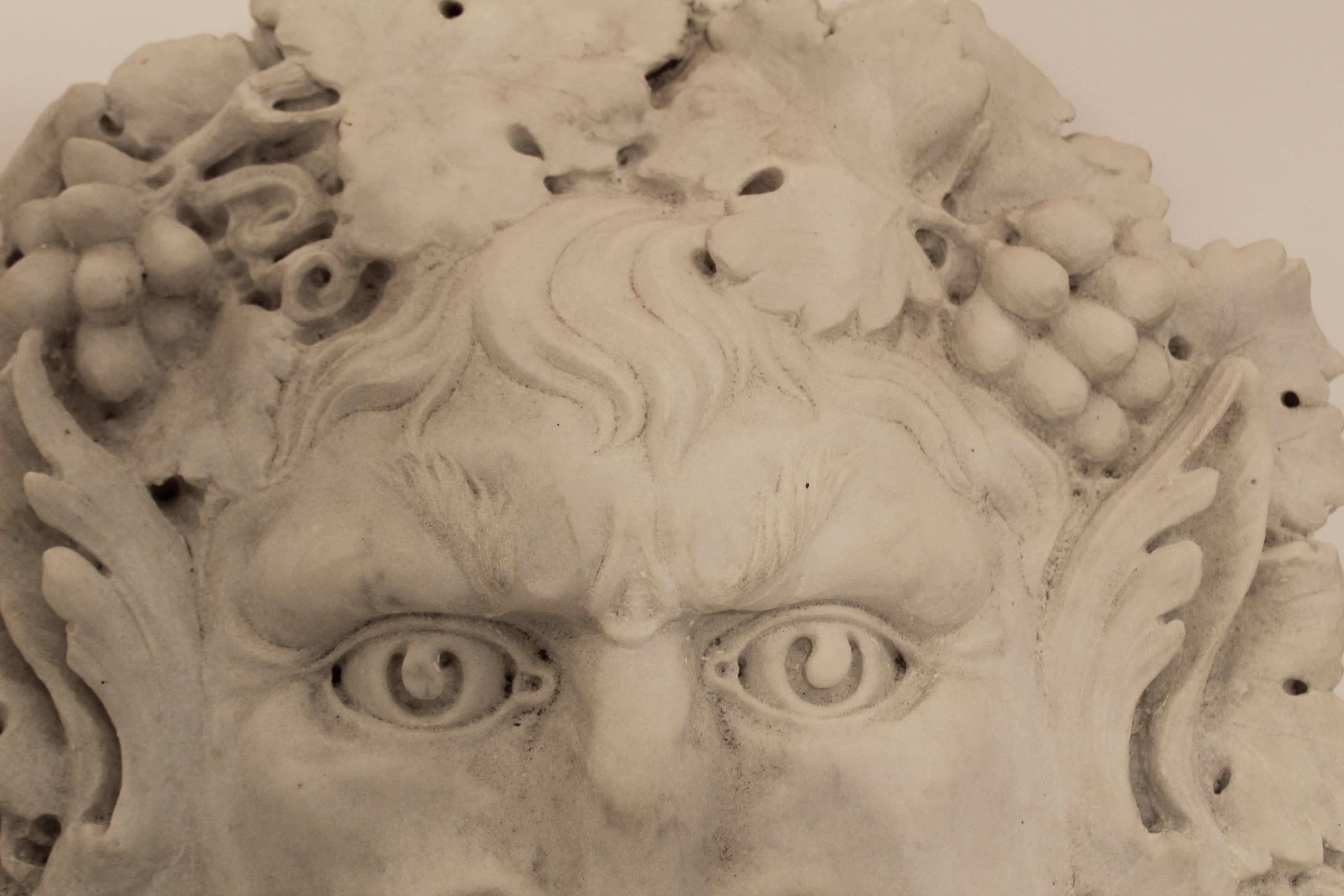 A 19th century Italian carved Carrara marble relief of Bacchus, the Roman god of agriculture, wine and fertility copied from the Greek god Dionysus.
He is portrayed with his eyes and mouth wide open, supposedly whispering to the growers at the