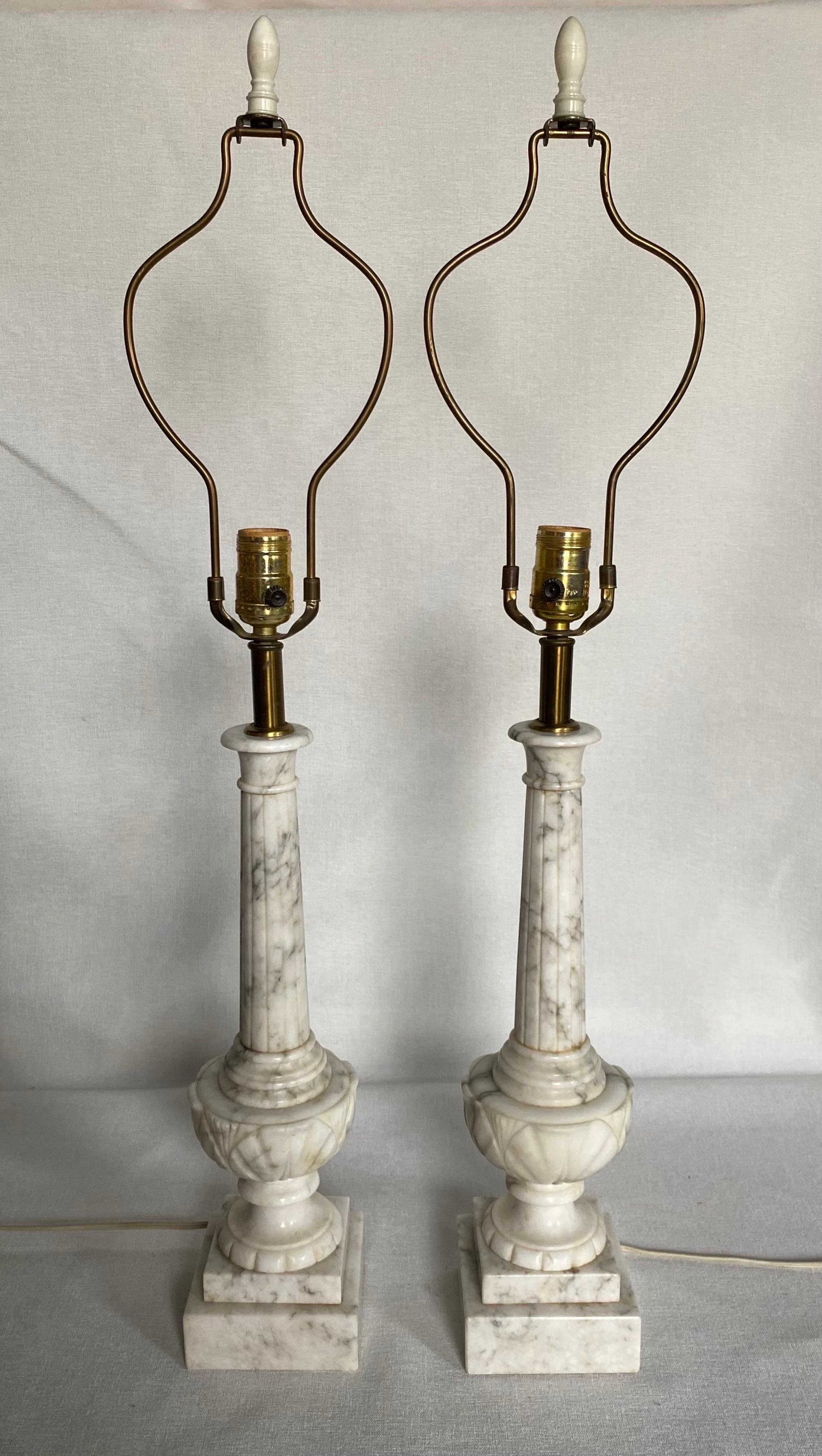 Beautiful pair of carved marble table lamps. These Neoclassical style lamps feature fluted columns and urn form bases mounted on square plinths. Perfect lamps for the bedside or dining buffet sideboard. 

Lamp shades not included.
